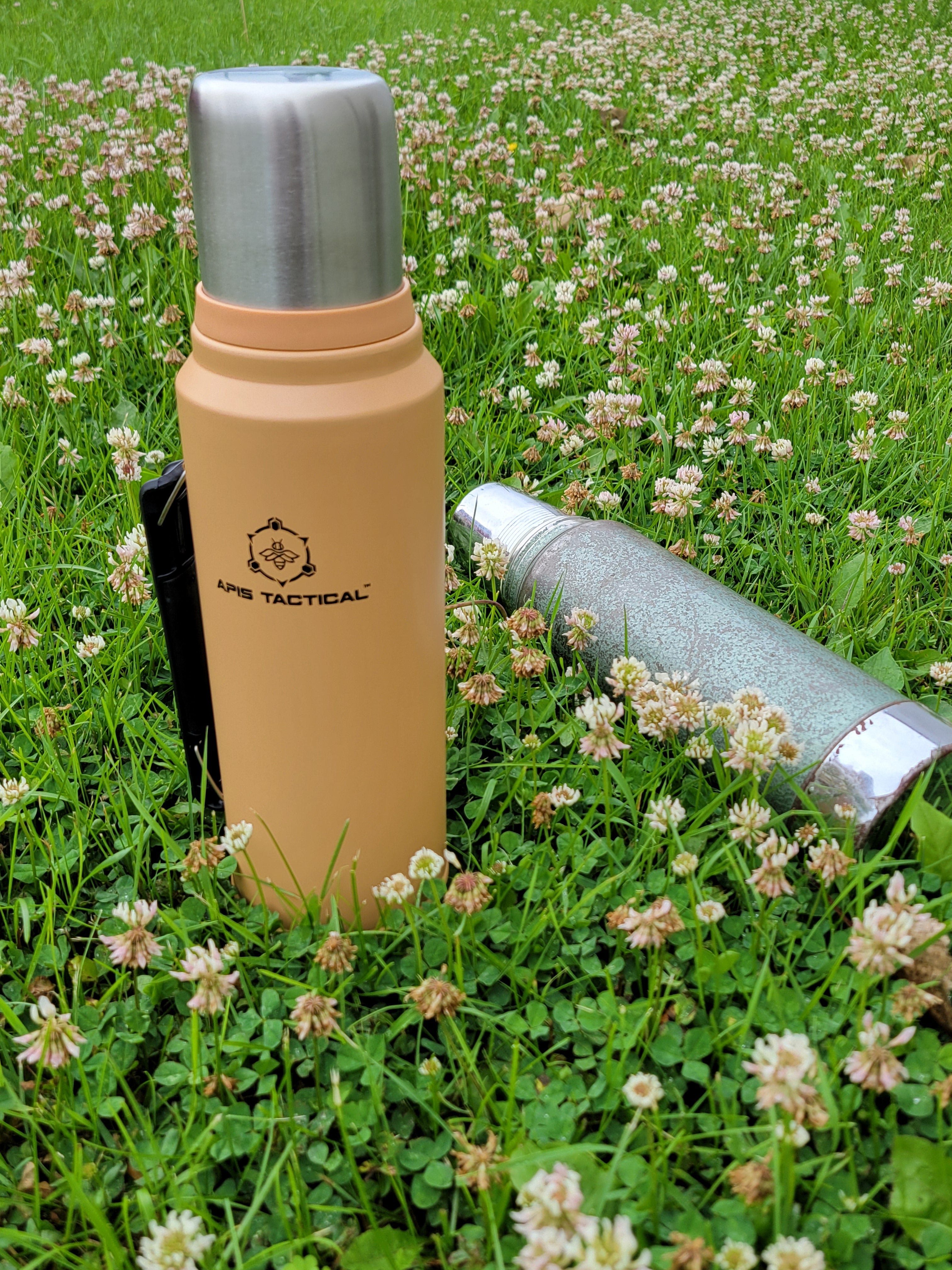 Apis Tactical 1qt insulated field thermos showing stainless steel body, black lid, and measurement markings for outdoor beverage storage.