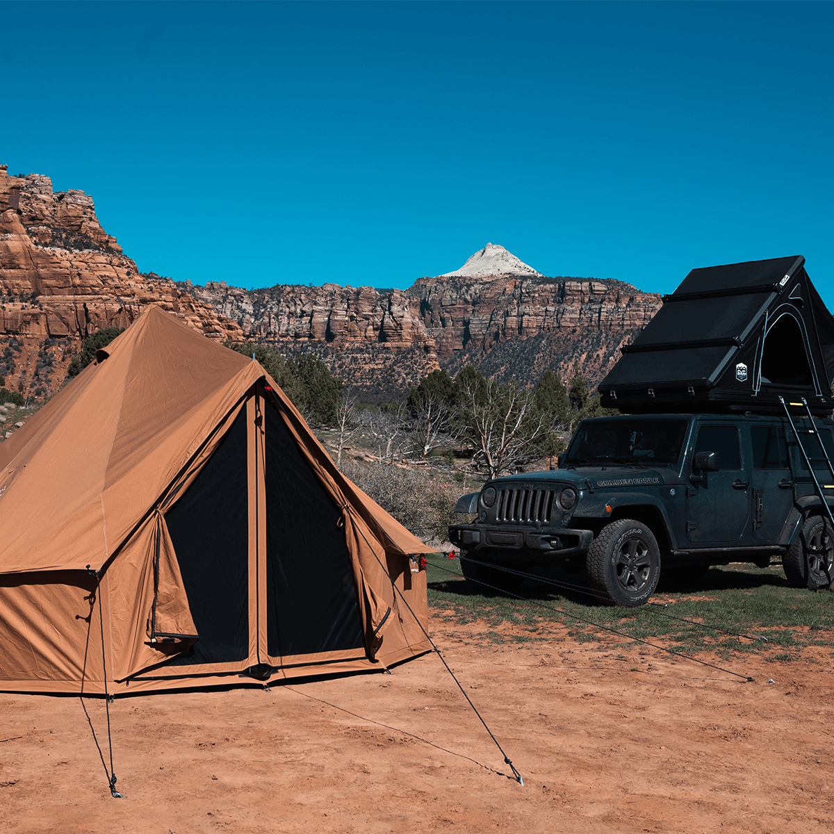 Sandstone beige 13' Regatta Bell Tent by White Duck Outdoors set up on a car in outdoor environment.