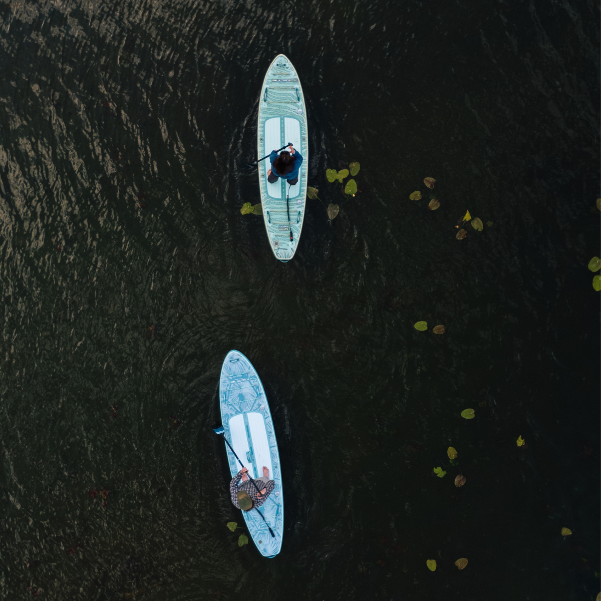iROCKER US CX ULTRA™ 3.0 paddle board on water, showcasing its sleek design and durable construction for all-level paddling.