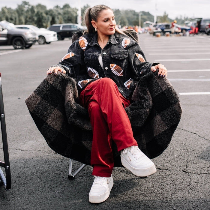 Grey plaid City Bonfires Chair Blanket draped over a chair, showcasing its cozy, soft fabric for outdoor and indoor use.