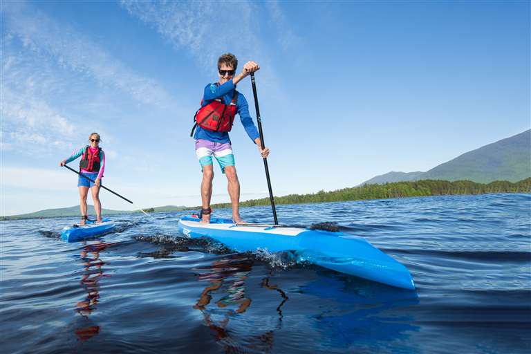 Backcountry Sportsman NN14 Pro NeedleNose inflatable paddleboard startup package with paddle and accessories on a stand-up paddleboard.