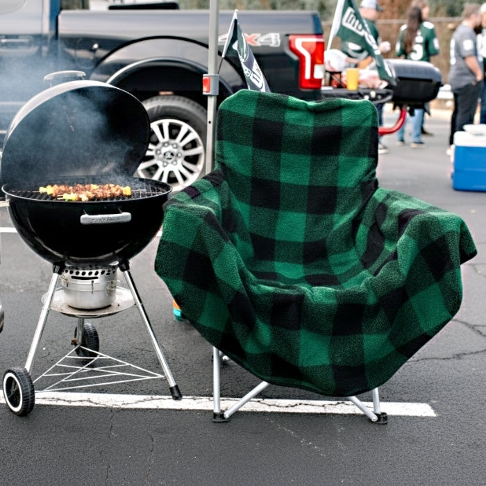 Green plaid Chair Blanket by City Bonfires draped over a chair, showcasing cozy, soft woven fabric for warmth and comfort.