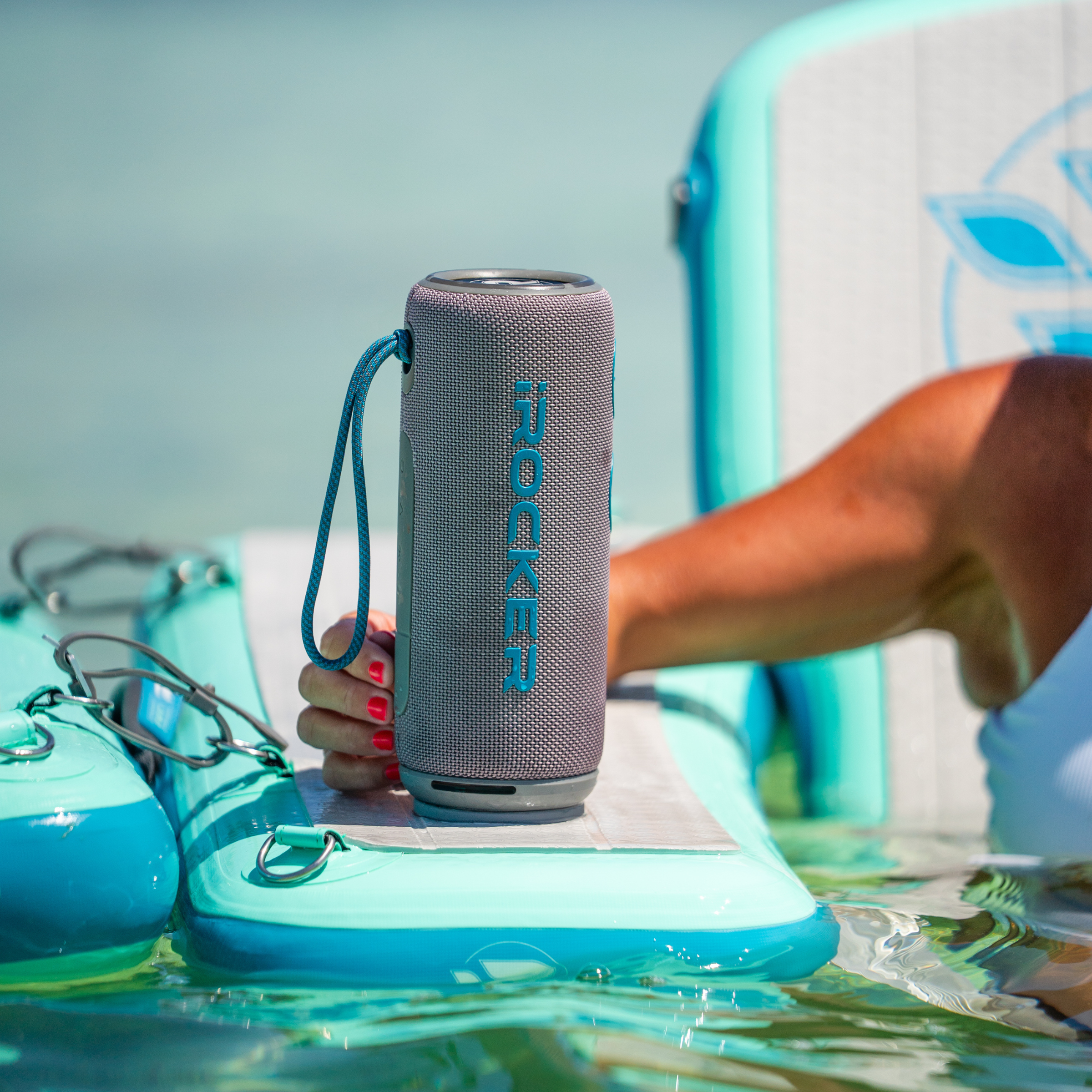 iROCKER US MAG SPEAKER X portable Bluetooth speaker with black design and textured surface, showing control buttons and branding.