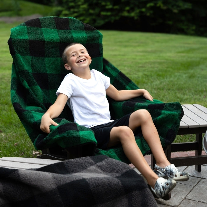 Green plaid chair blanket from City Bonfires, cozy and soft throw blanket draped over a chair for warmth and comfort.