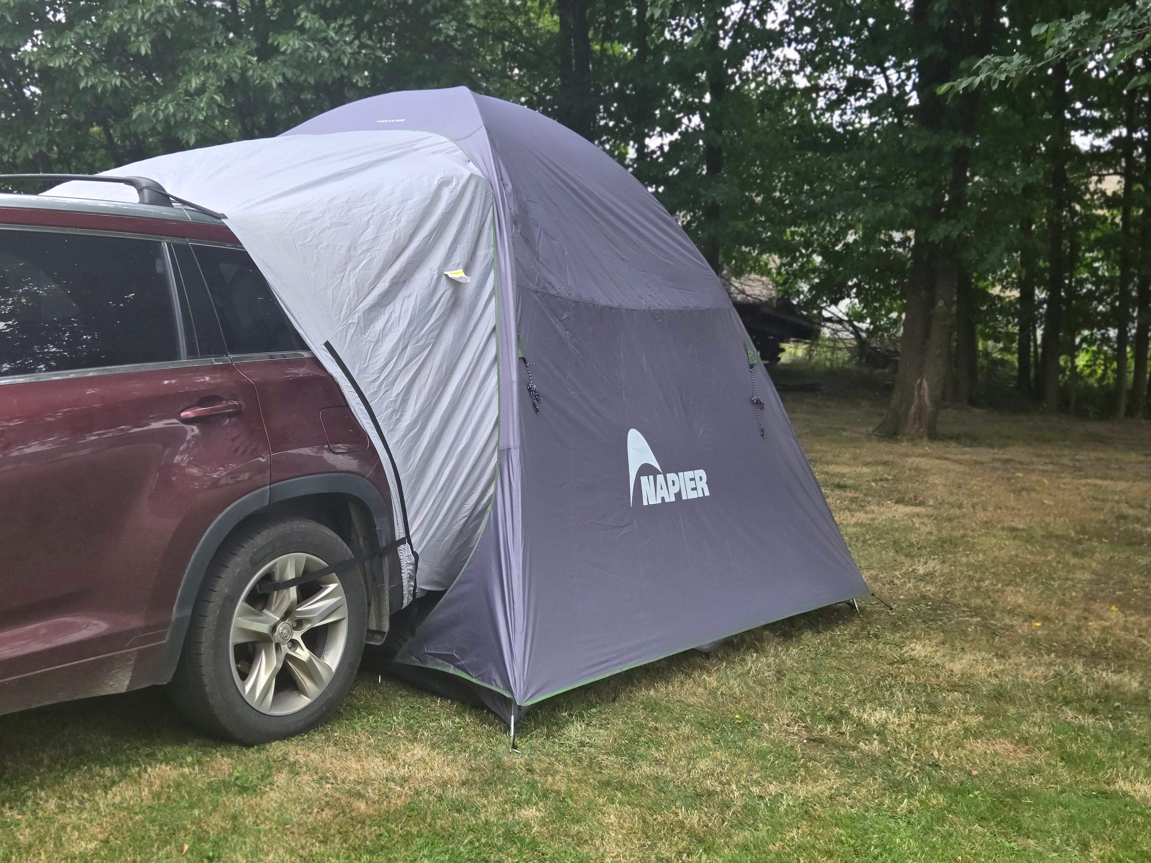 Backroadz SUV Tent by Backcountry Sportsman set up over an SUV, shown in outdoor camping environment with trees and open sky.