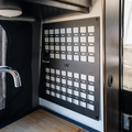 Revel Kitchen MOLLE panel by Canyon Adventure Vans, made in Utah, showing durable metal hooks and attachment points for versatile gear storage.