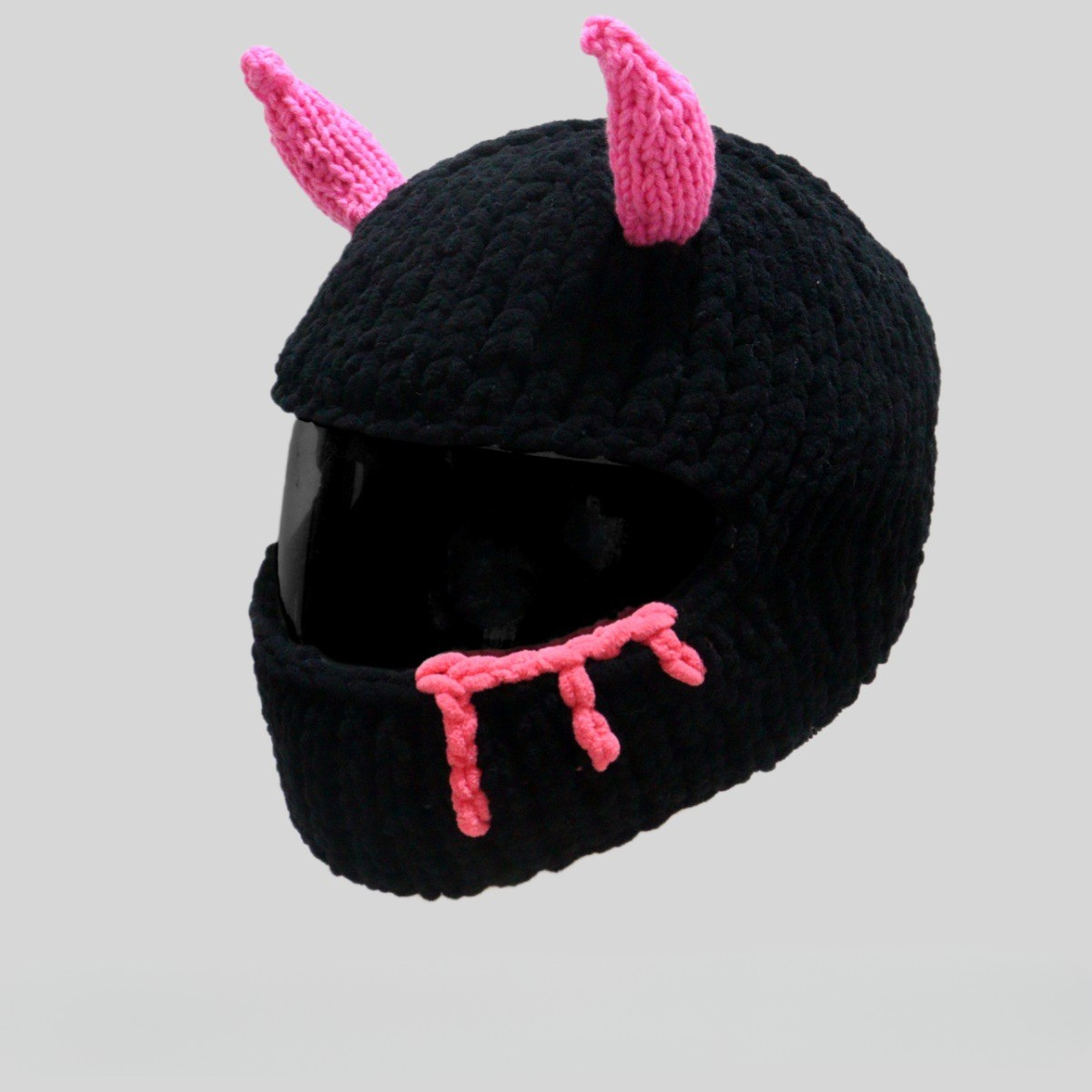 Handmade knitted little devil helmet cover by Bean's Moto Booth, designed as a fun helmet accessory with red devil horns.