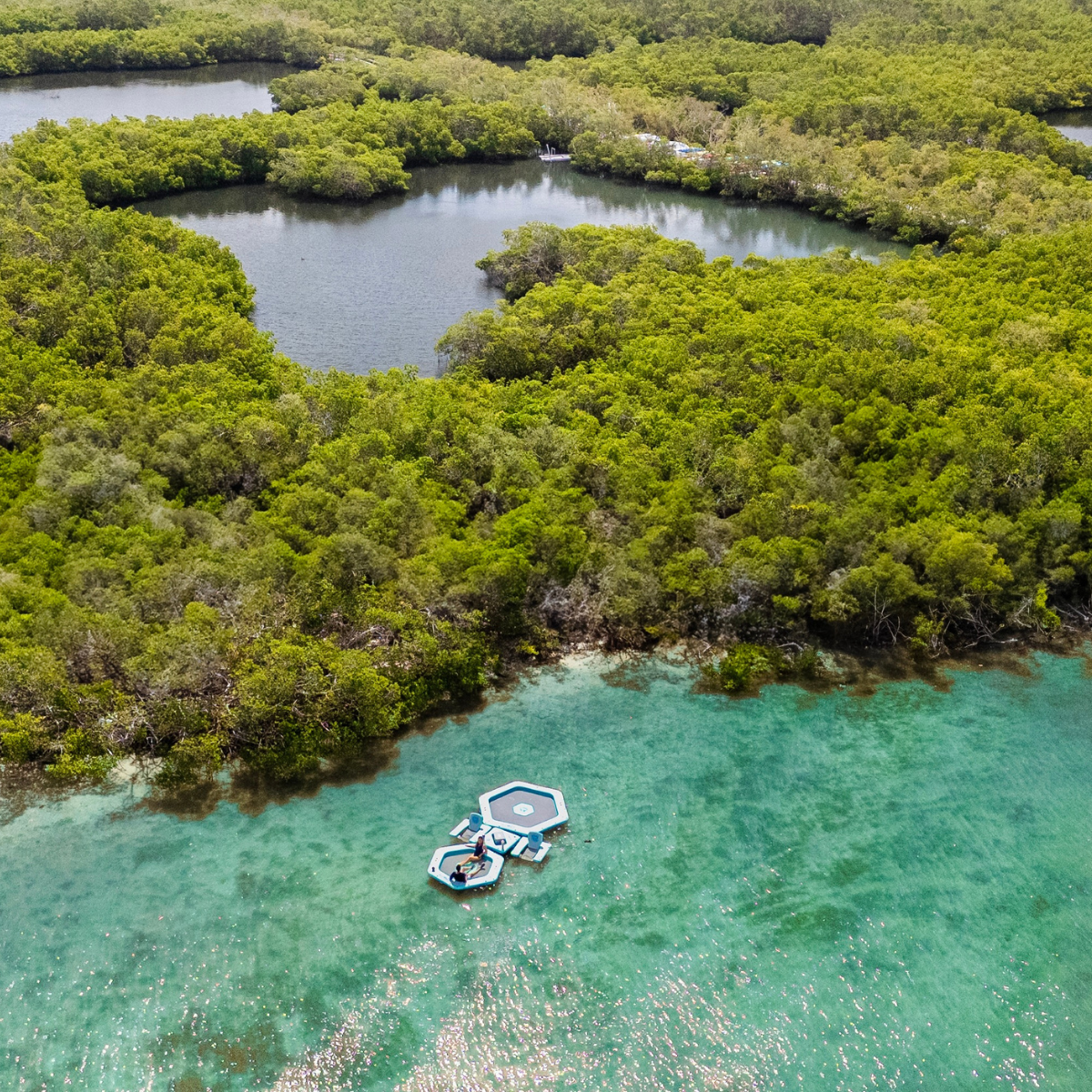 iLAND® 10' inflatable float from iROCKER US, showing a bright blue and green design on the water.