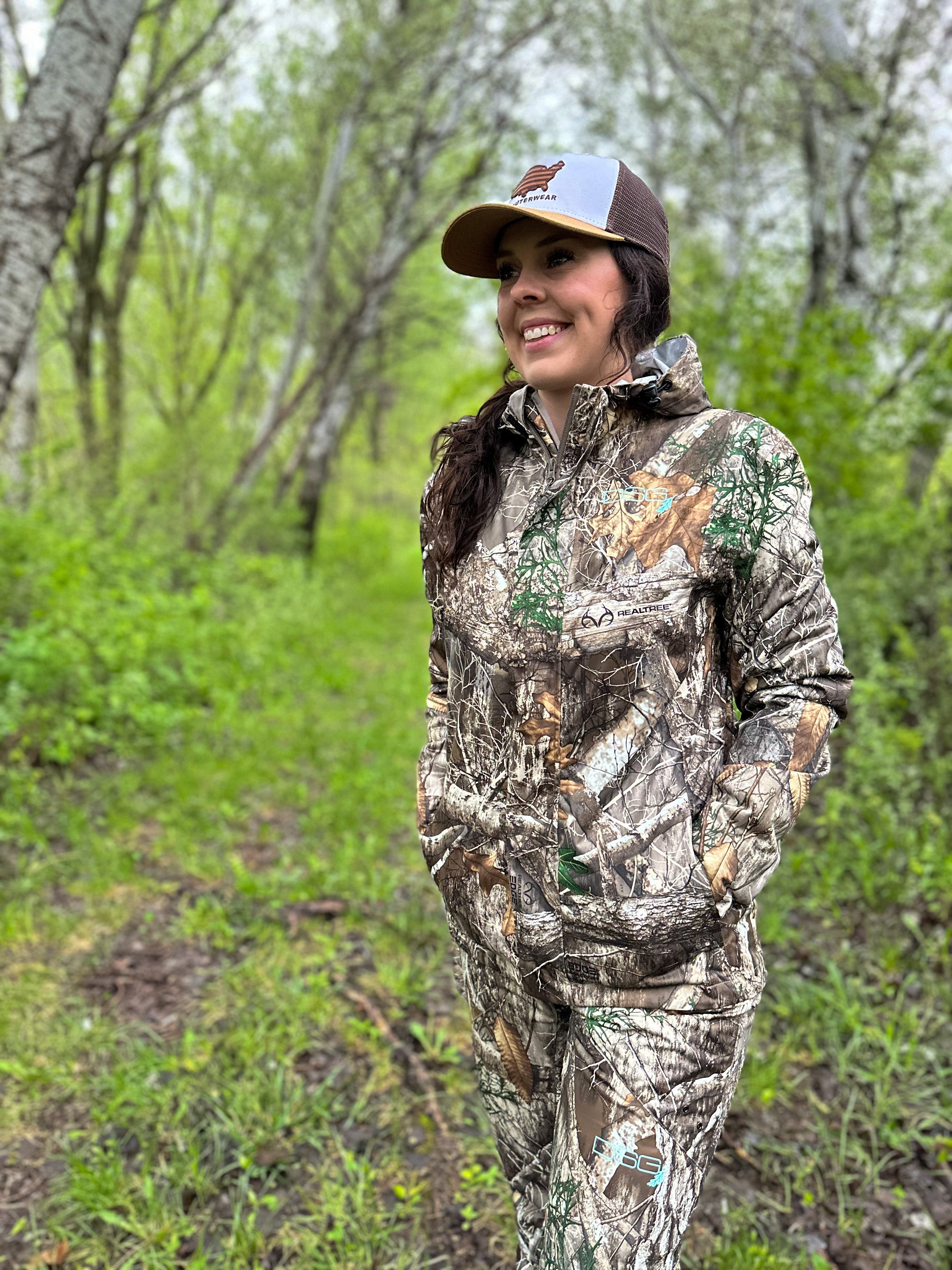 DSG OUTERWEAR Nova rain jacket shown on a hanger, lightweight waterproof outdoor jacket in bright blue with a hood and zipper closure.