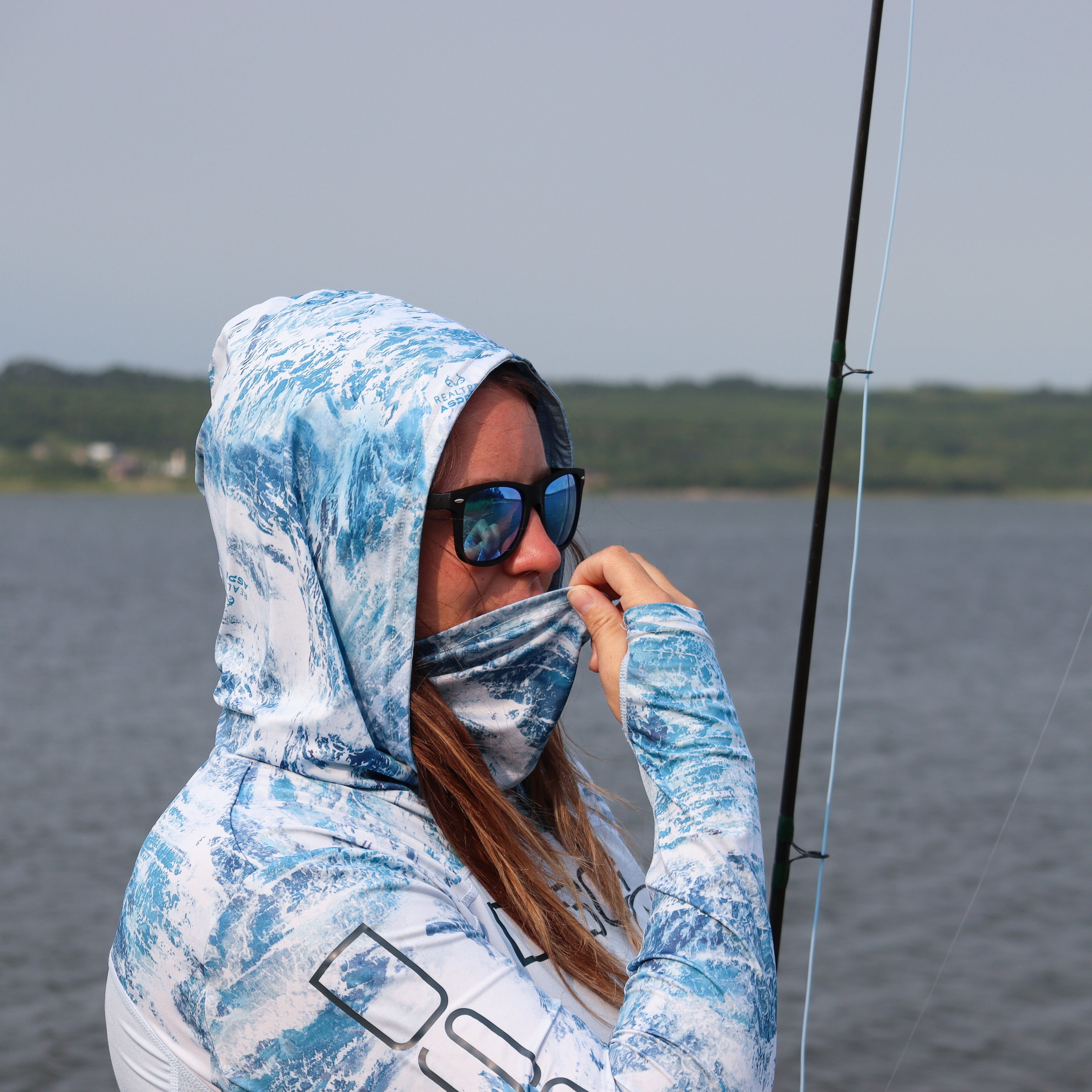 Chloe hooded shirt by DSG OUTERWEAR featuring UPF 50+ sun protection, shown in a casual outdoor setting.