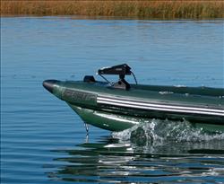 Backcountry Sportsman FishSkiff™ inflatable fishing boat with two-person swivel seat set on water, ready for outdoor fishing adventures.
