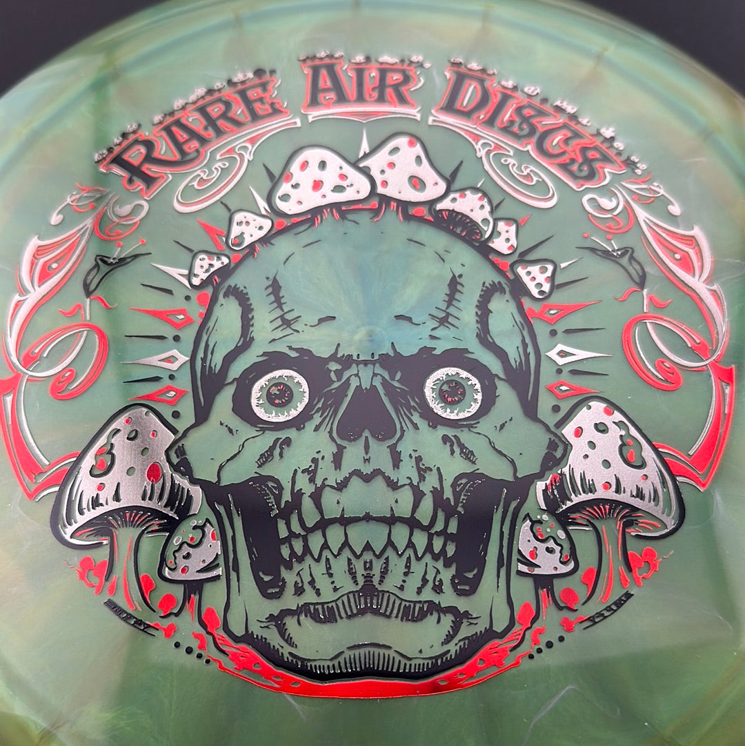 Disc golf stamp by Manny Trujillo on Ethos Construct Crushin' Amanitas disc from Rare Air Discs, featuring colorful mushroom artwork.