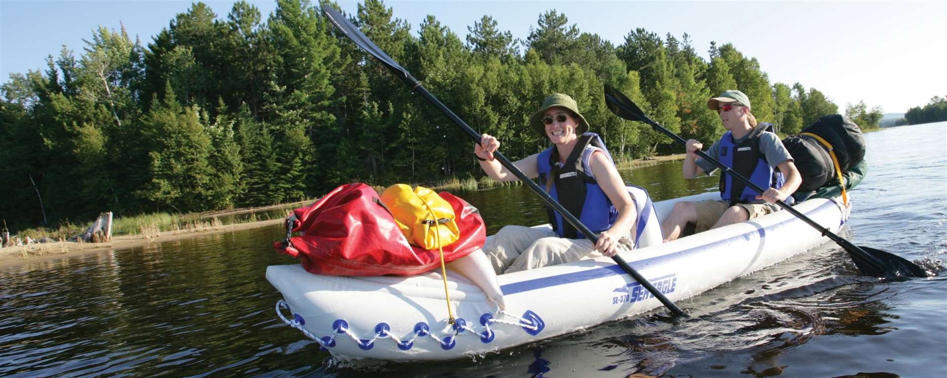 Backcountry Sportsman SE370 Sport Inflatable Kayak on water, showing its bright orange color and streamlined design.
