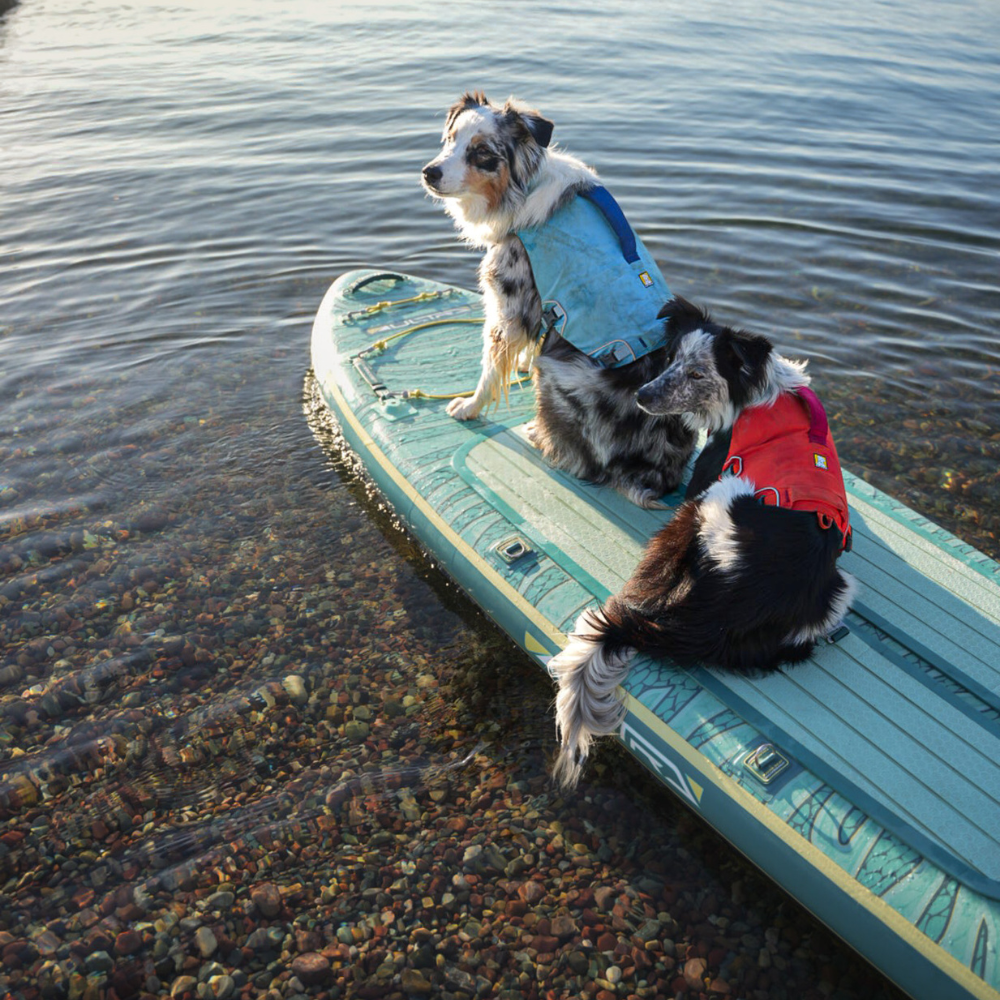 iROCKER US CX ULTRA™ 3.0 paddle board lying on the water with a sleek, streamlined design and bright color accents.