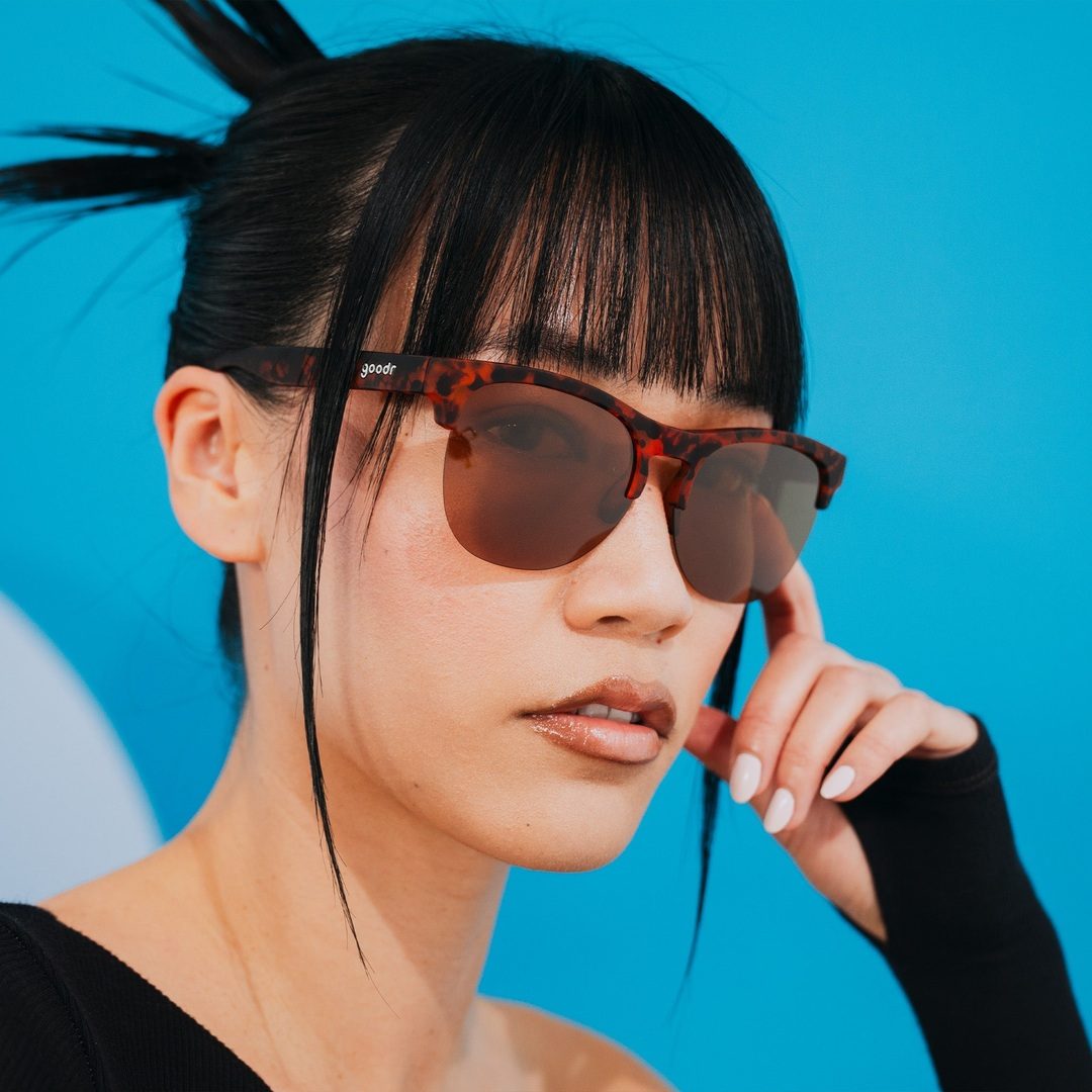 Pair of Positively Cosmopolitan Avant G Polarized Sunglasses by Rare Air Discs shown on a lifestyle background.