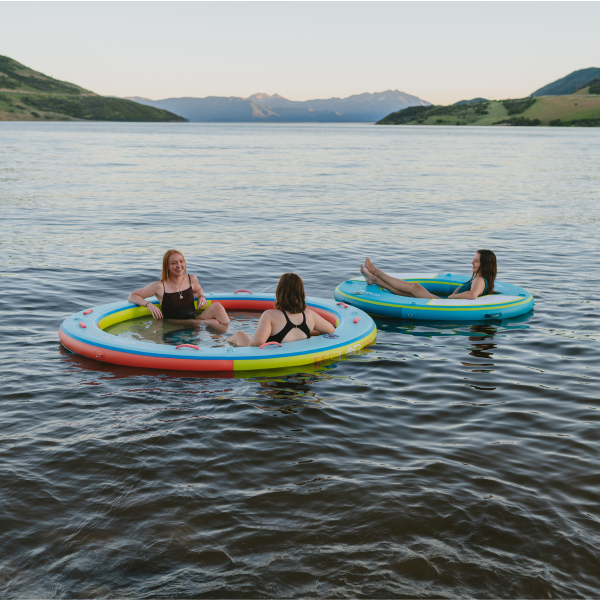 iLAND® by iROCKER 6-foot round float in vibrant colors, designed for relaxing in the water at the beach or pool.