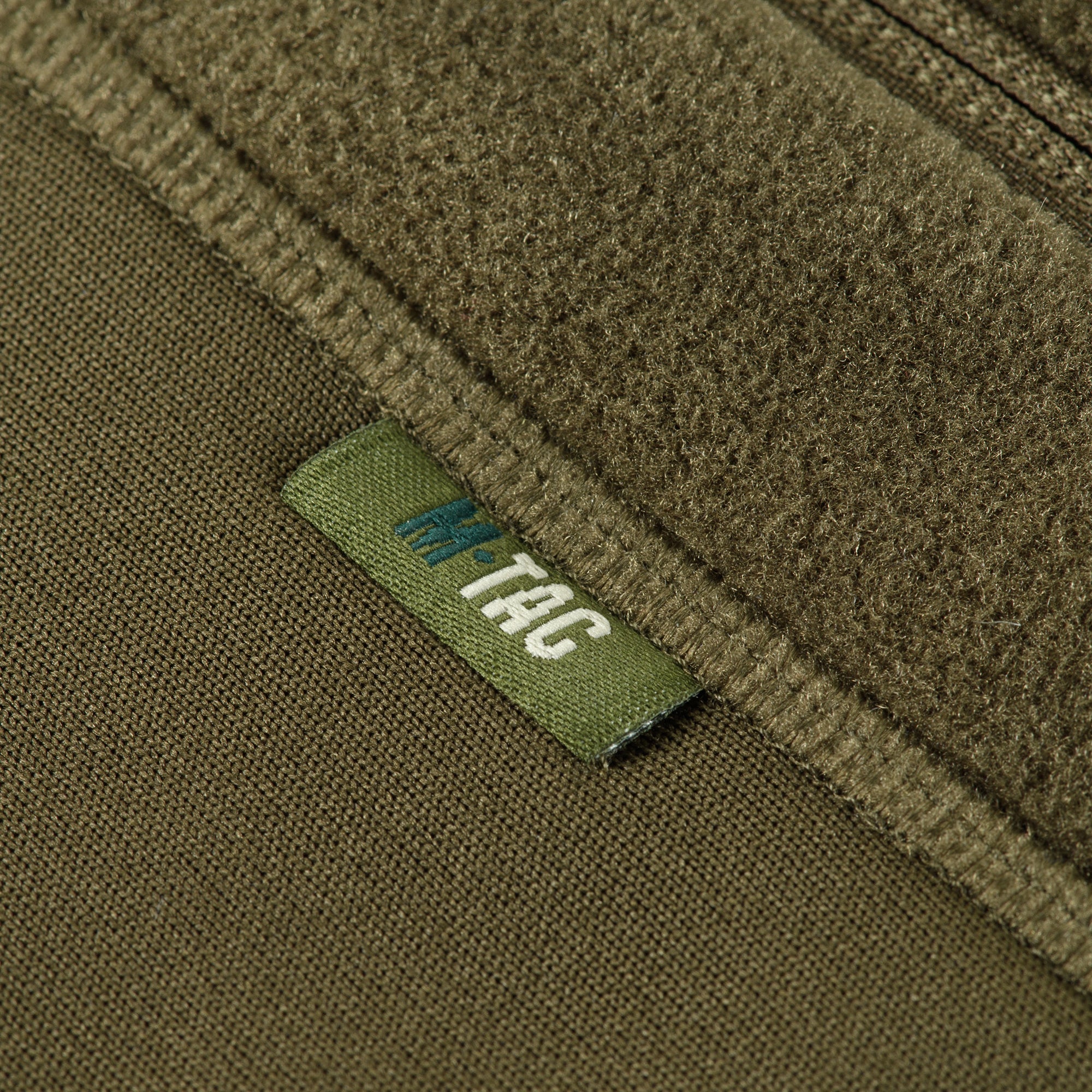 M-TAC Polartec fleece jacket in green, showcasing a zip-up design and soft texture, perfect for outdoor activities.