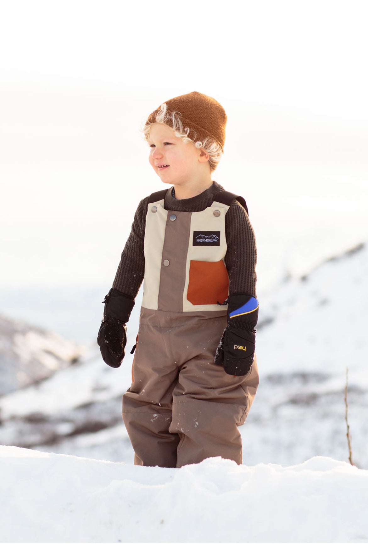 Waterproof snow bib for youth and toddlers by Keep the Littles Wild, featuring adjustable straps, padded knees, and vibrant color.