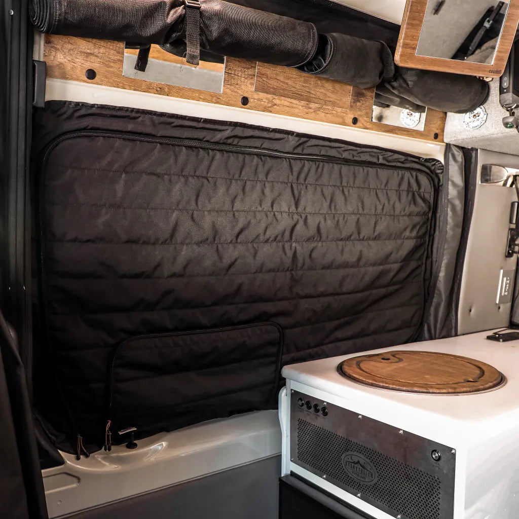 Canyon Adventure Vans CLIMA-SHADE™ insulated sliding door window cover on Storyteller Overland Mode van, blocking sunlight and providing privacy.