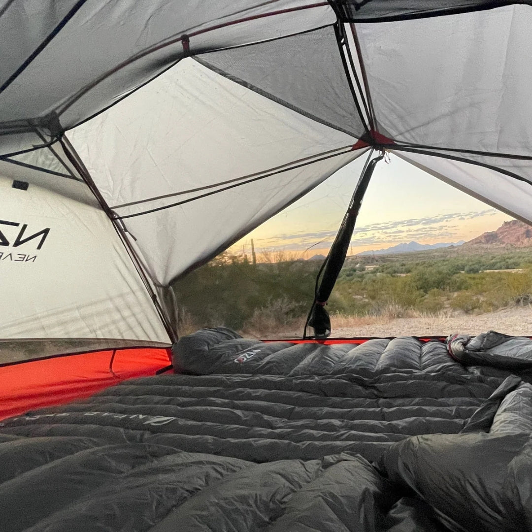 Near Zero Outdoor Gear 3P DynaLite Tent set up outdoors with rainfly and mesh windows, showcasing lightweight camping shelter.