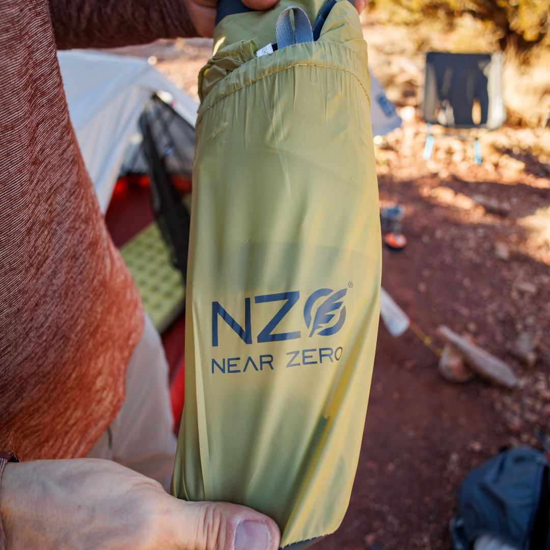 Near Zero Outdoor Gear insulated inflatable sleeping pad with quilted surface and adjustable air valves for camping comfort.
