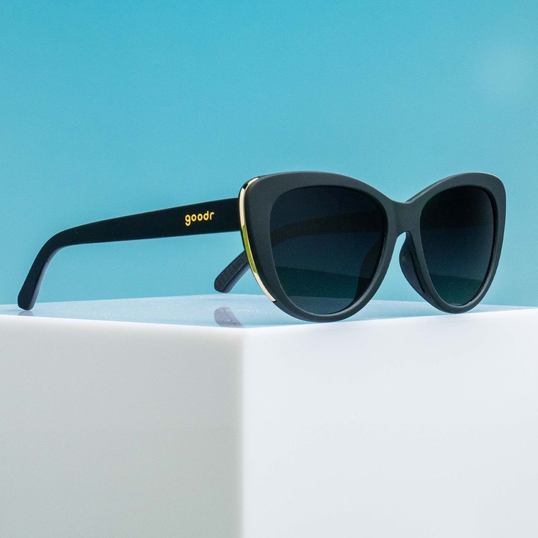 Four pairs of "It's Noir, Darling" Glam G polarized sunglasses in packaging, stylish accessories by Rare Air Discs.