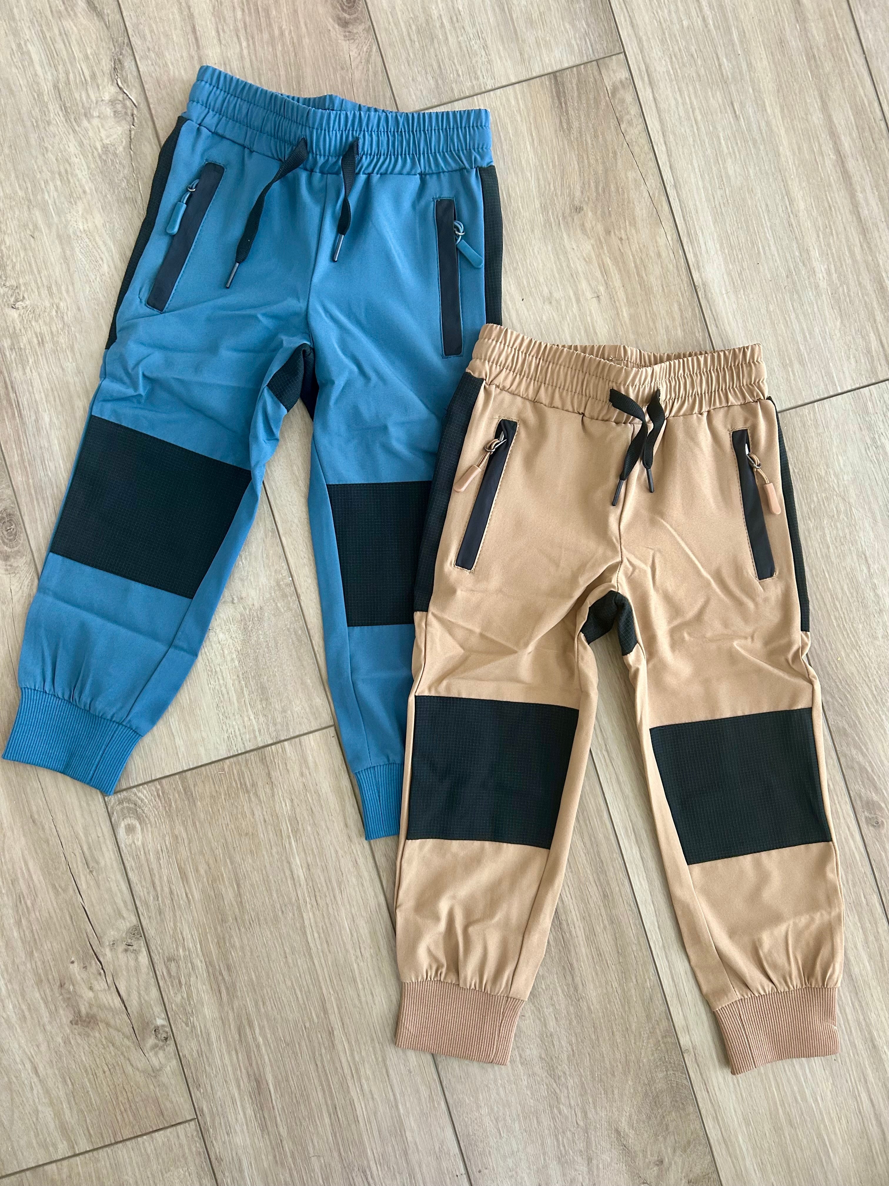 Keep the Littles Wild water-resistant tan hiking pants displayed on a hanger, showcasing durable outdoor apparel for kids