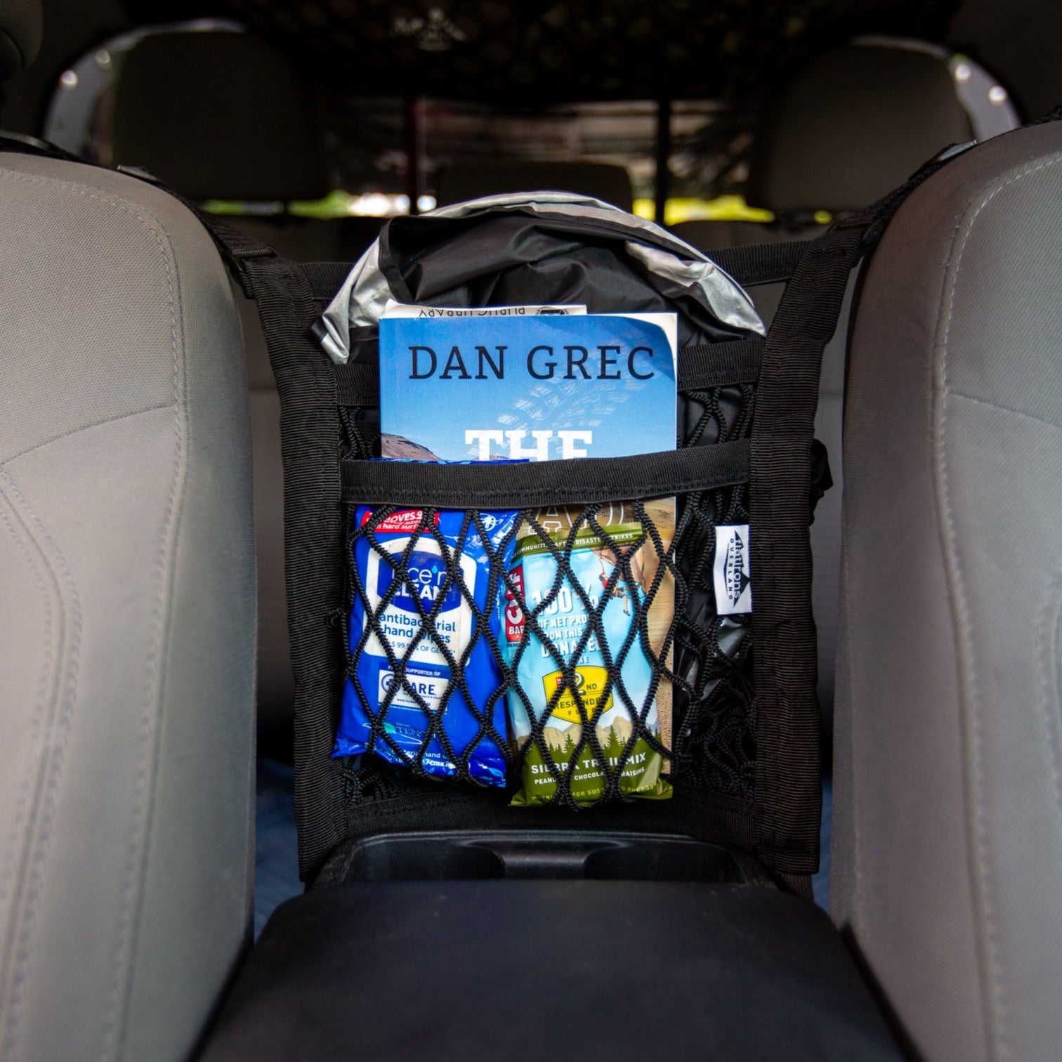 Universal seat divider storage net by Flatirons Overland, shown installed in vehicle interior for organizing space.