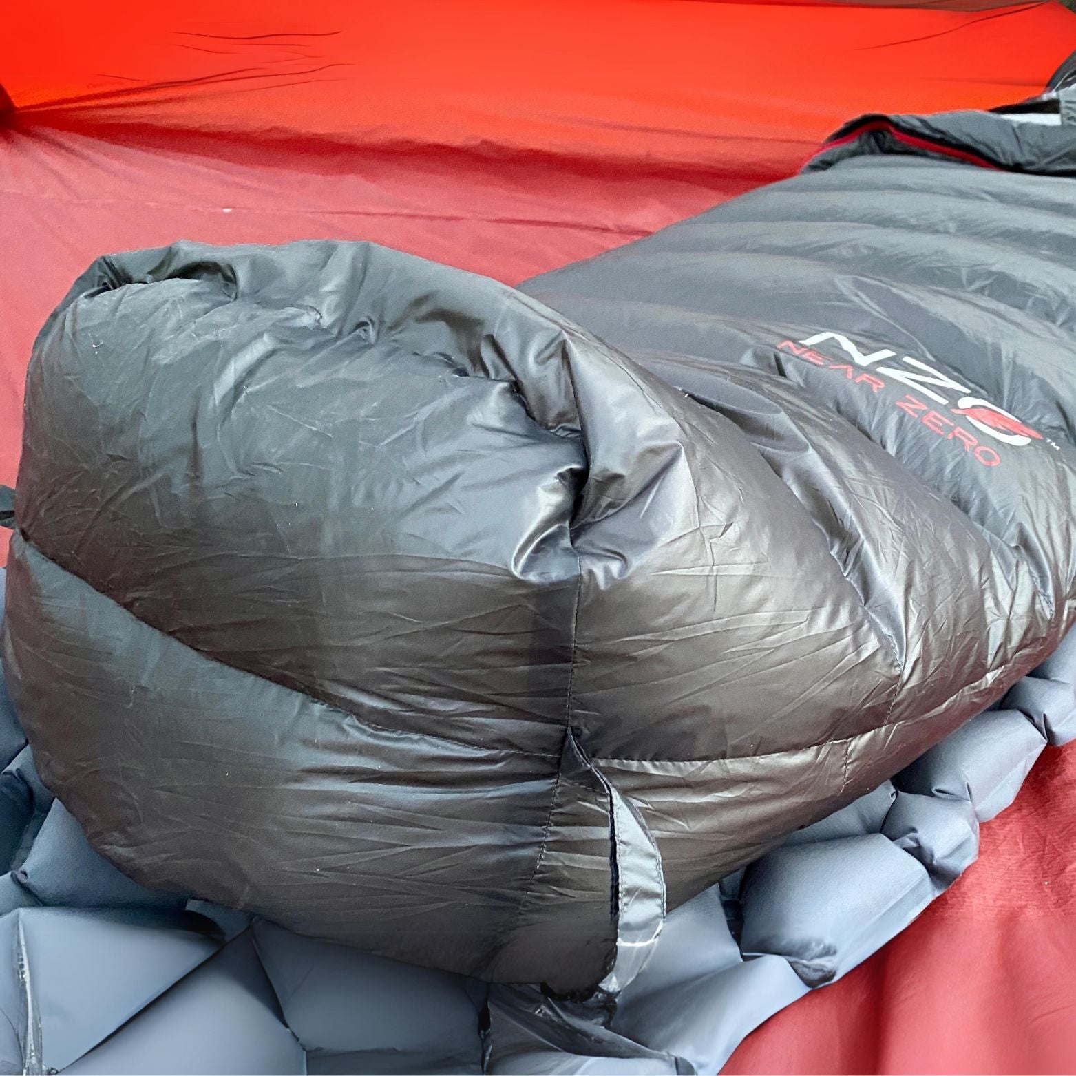 Near Zero Outdoor Gear NZ 20 Mummy Sleeping Bag in green, showcasing its tapered design and zipper detail for camping.
