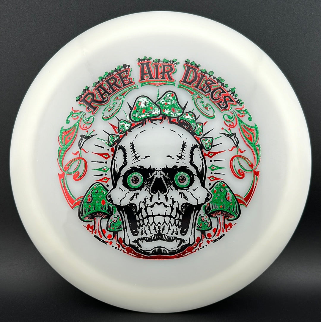 Disc golf stamp by Manny Trujillo featuring Forged Radiant Era - Crushin' Amanitas design on Rare Air Discs for disc golf players.