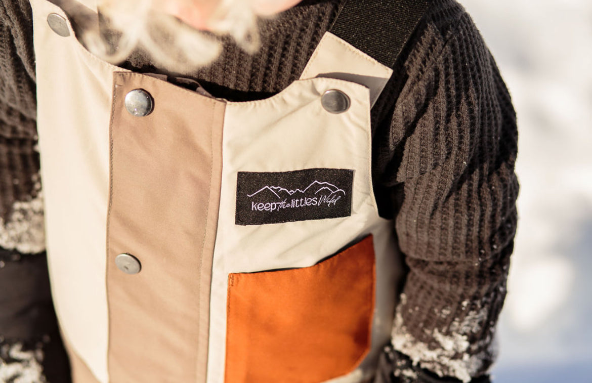 Waterproof snow bib for youth and toddlers by Keep the Littles Wild, showing the insulated, colorful winter bib with adjustable straps.