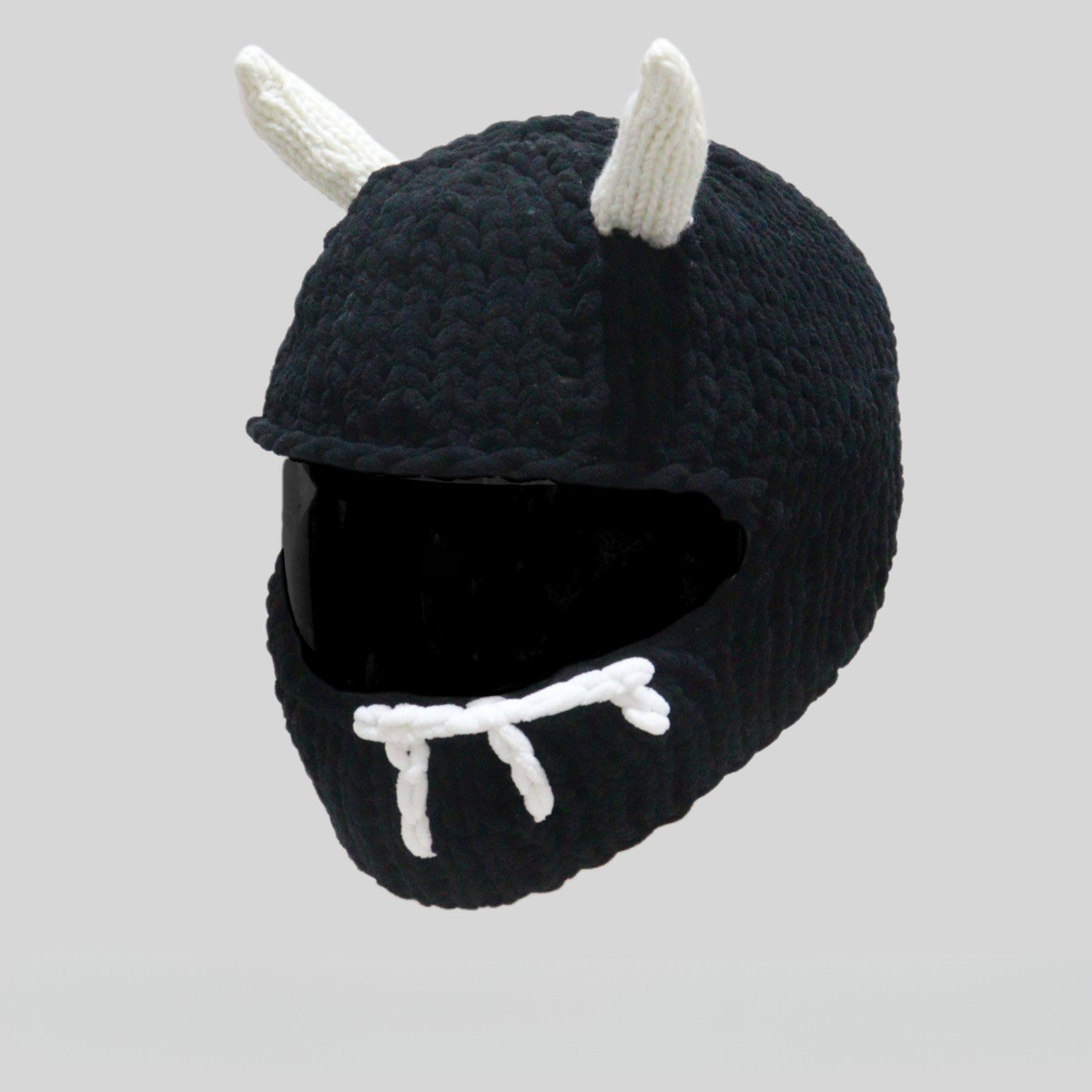 Handmade knitted little devil helmet cover by Bean's Moto Booth, featuring red and black yarn with devil horn details.
