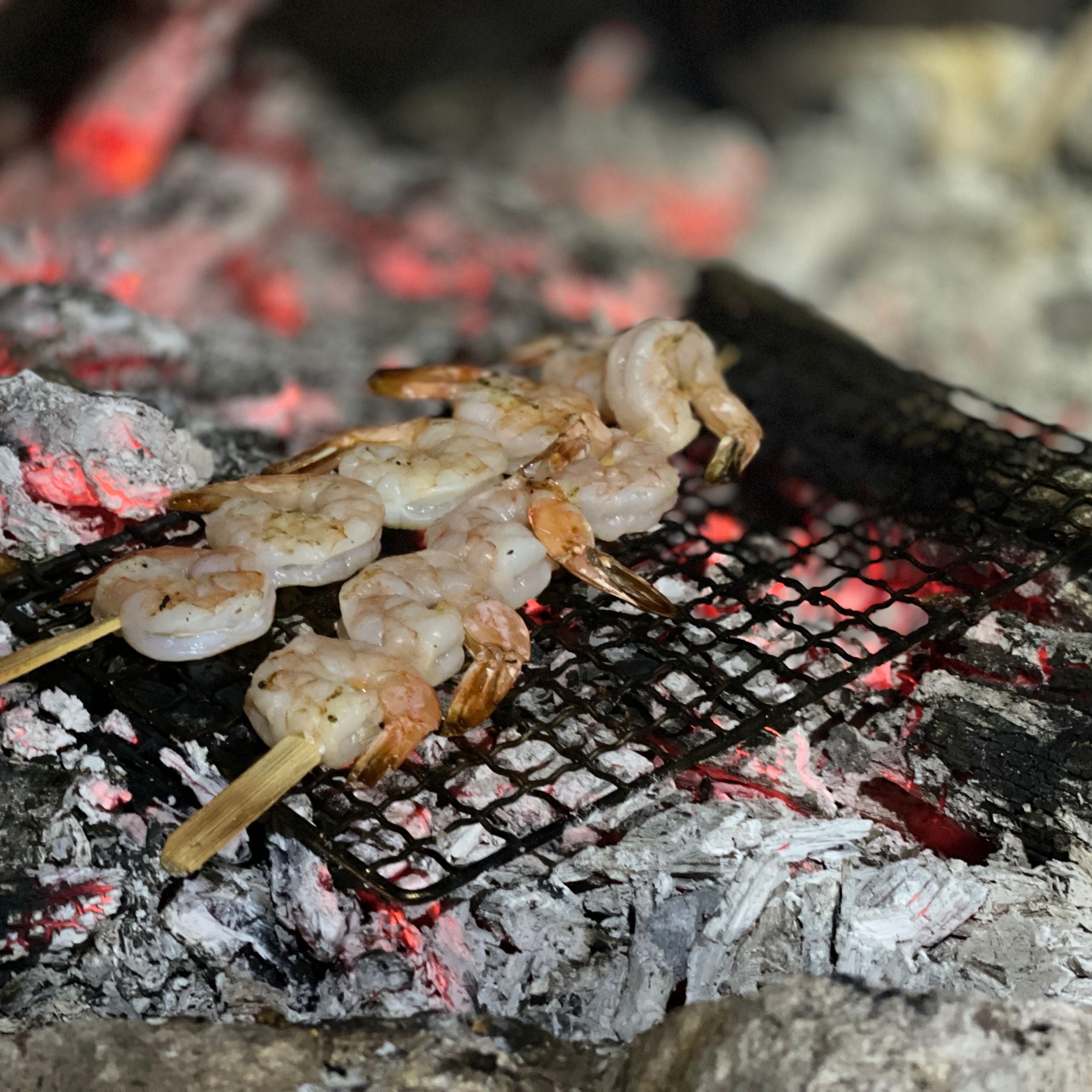 Stainless steel grill by Near Zero Outdoor Gear, showing a portable design for camping cookware and dinnerware.