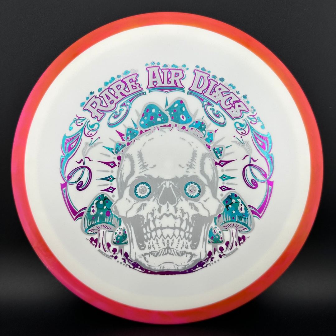 Disc golf disc Fission Defy Crushin' Amanitas VIP 2.0 by Manny Trujillo, produced by Rare Air Discs, shown on a plain background.