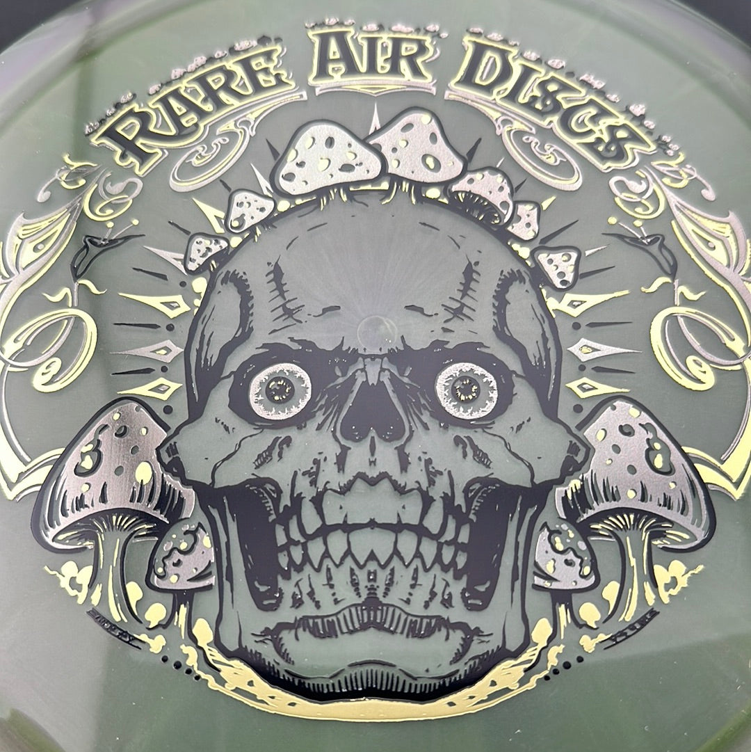 Disc golf stamp by Manny Trujillo featuring crushin' Amanitas on the Rare Air Discs Ethos Construct disc.