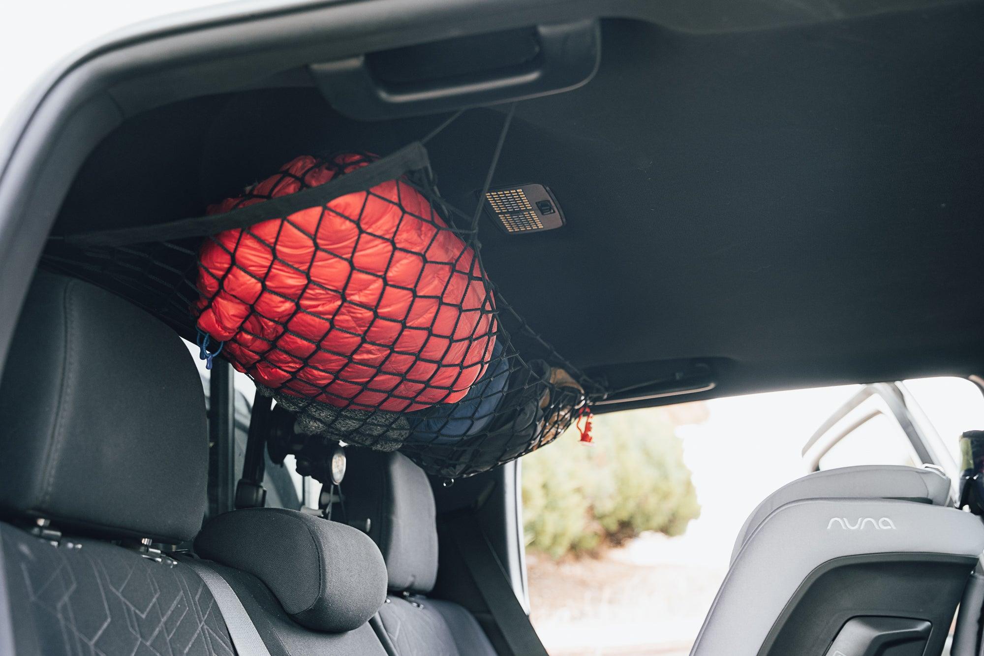 Toyota Tacoma attic storage net by Flatirons Overland installed in the vehicle's cargo area for organizing gear.