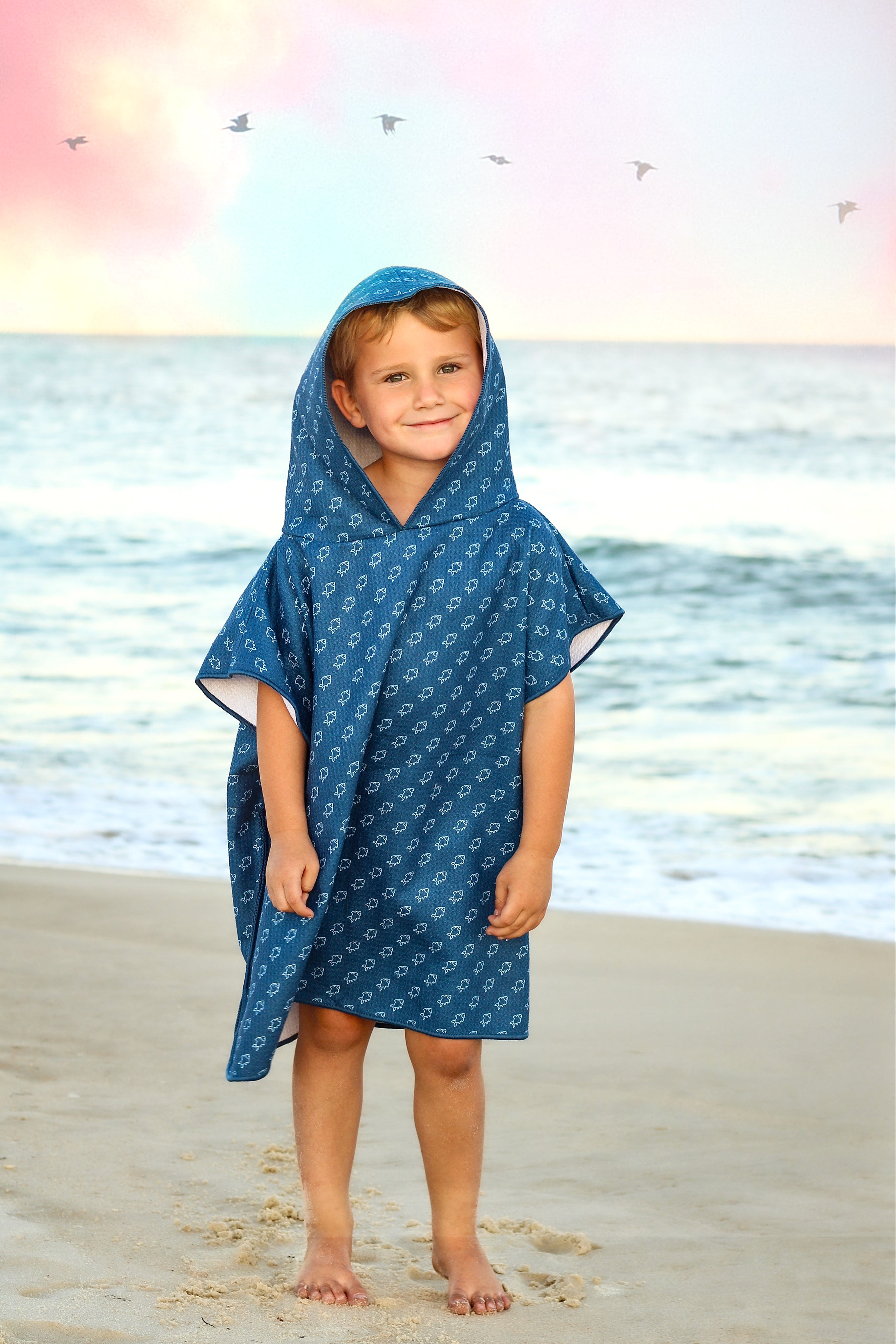 Blue microfiber fish waffle wearable towel by Keep the Littles Wild, shown draped with a playful fish design for children.
