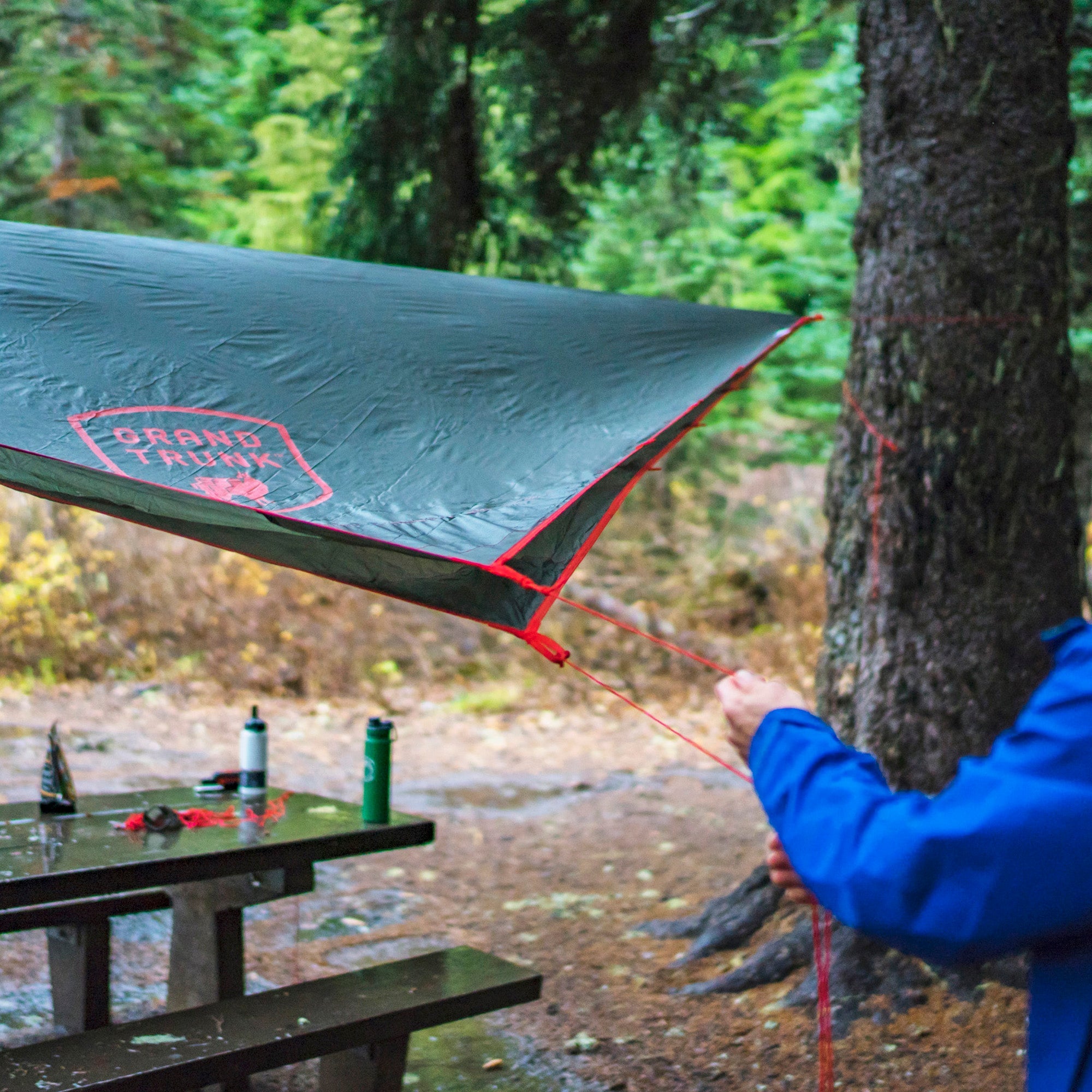 GrandTrunk Abrigo Rain Fly and Shelter setup showing lightweight, waterproof shelter in outdoor camping environment.