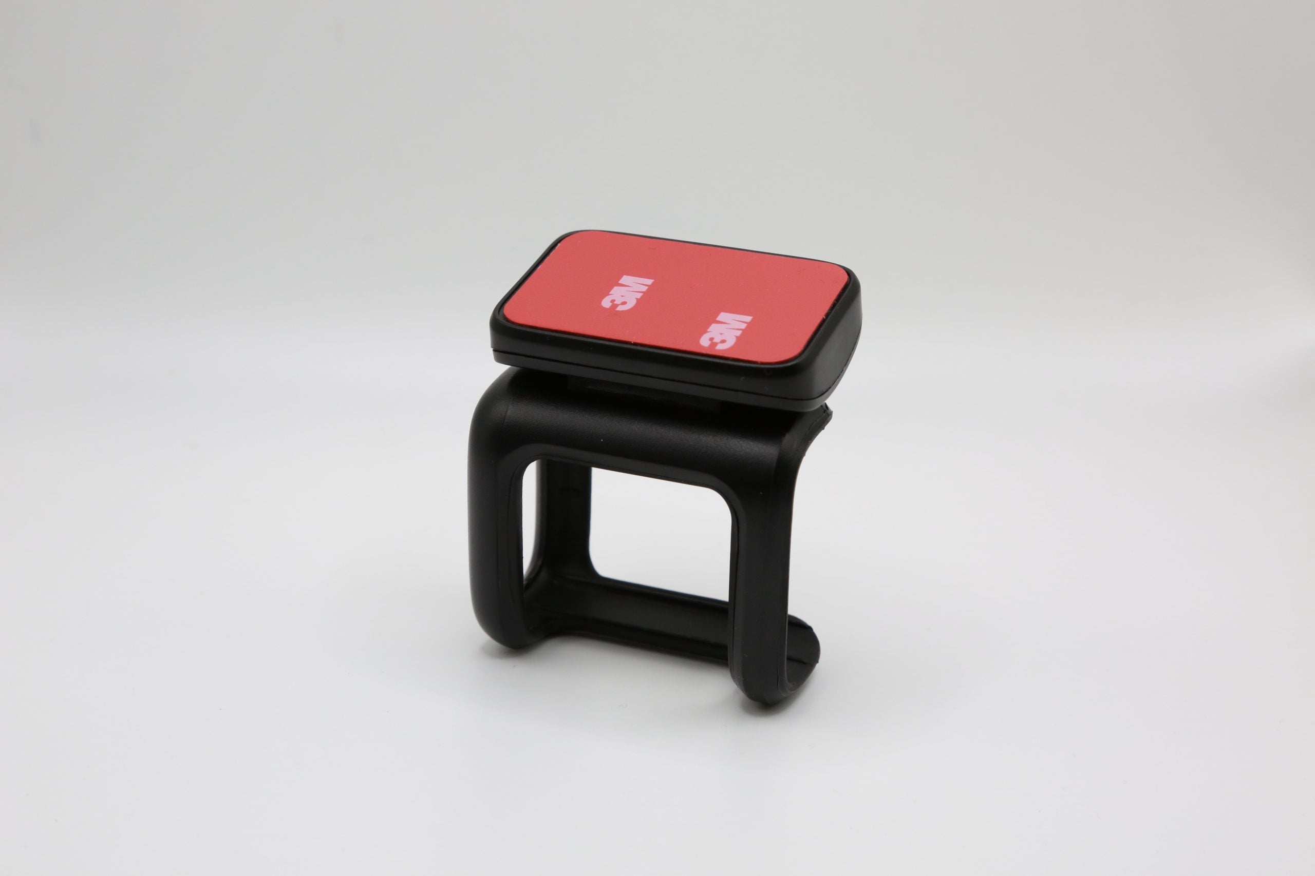 Rexing adhesive mount for DT2 dash camera, clear view of the black mounting clip with adhesive backing ready for installation