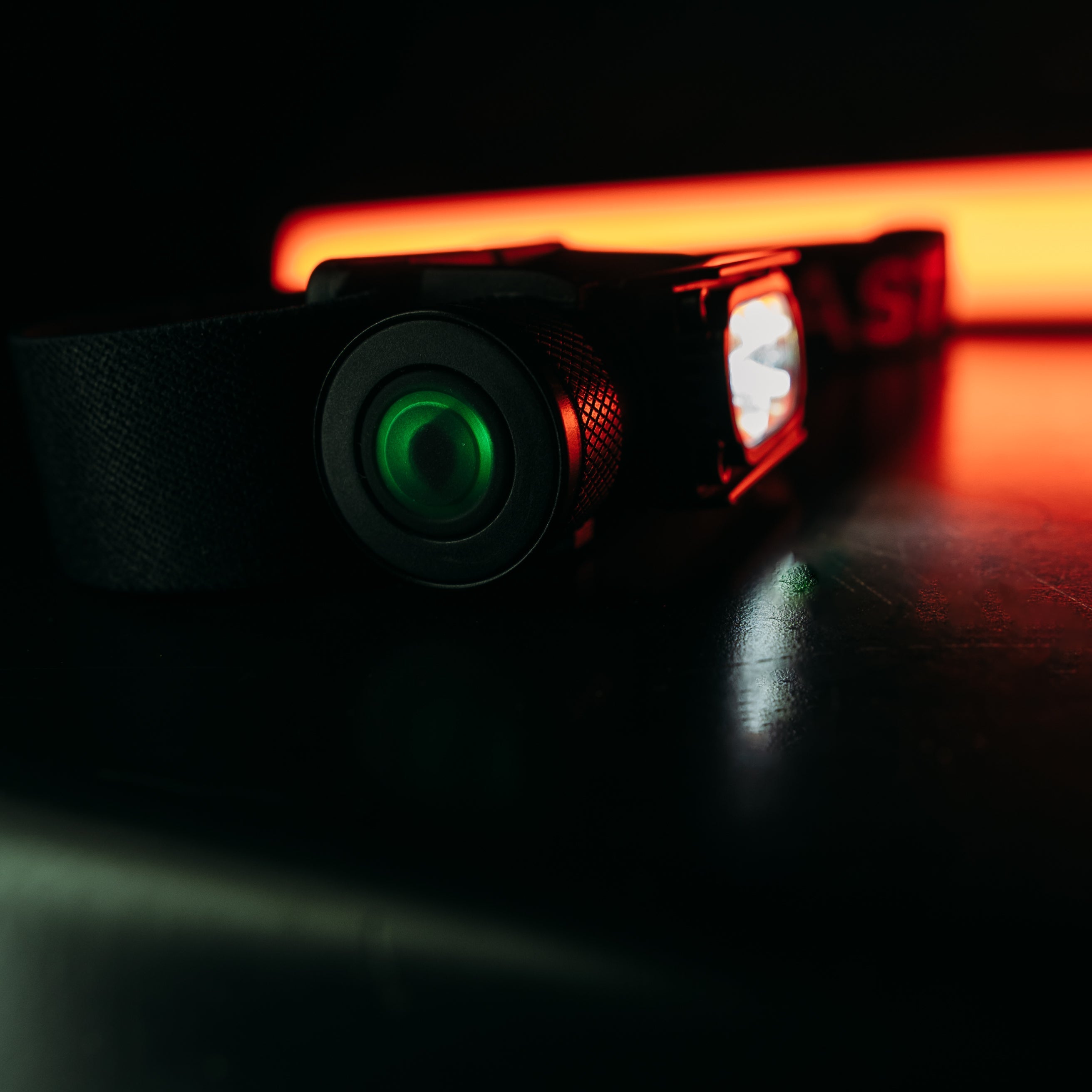 Bright white Last Light LLC Strike 1800 headlamp with adjustable straps and high-intensity LED light for outdoor activities.