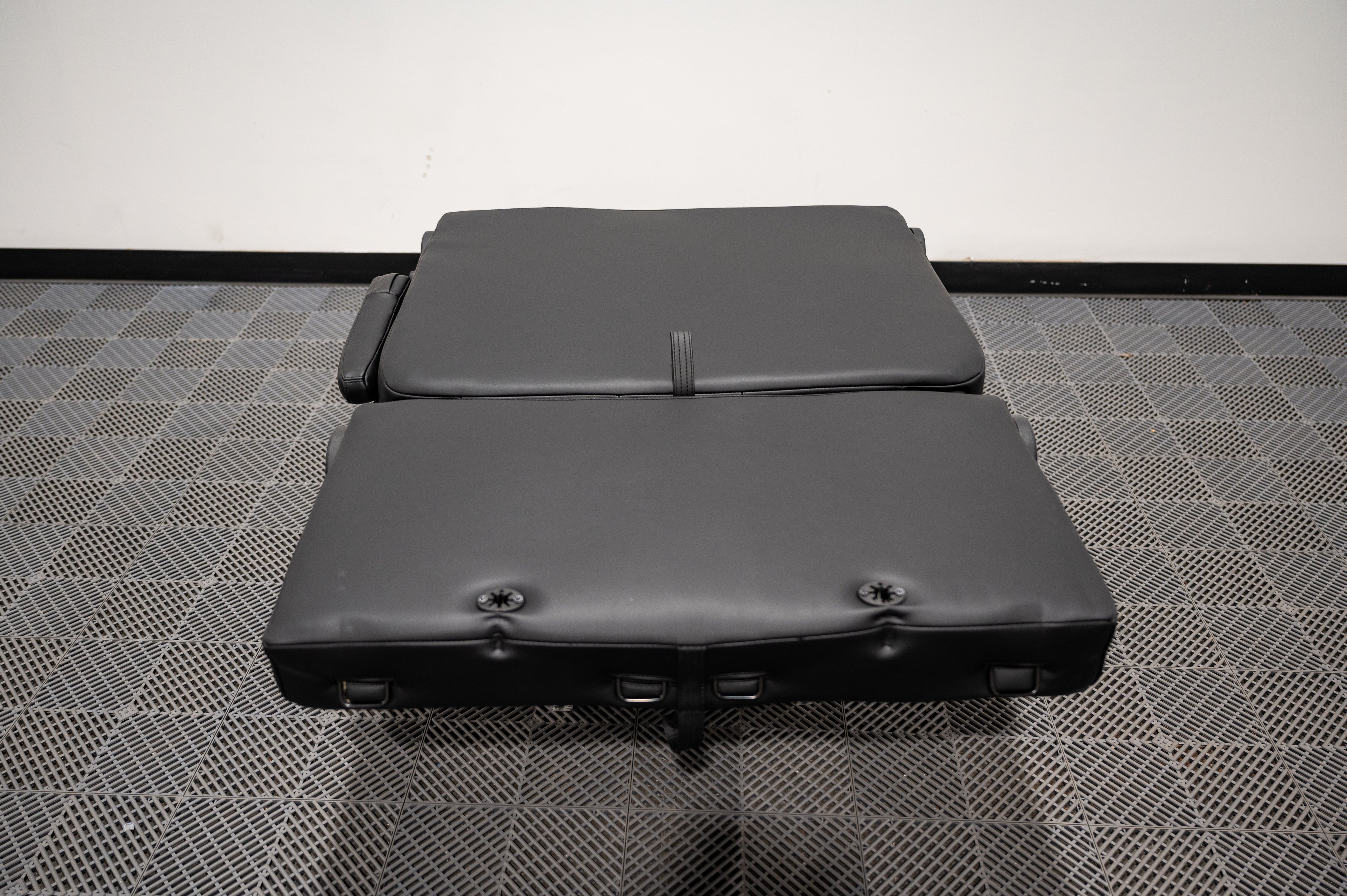 Alpine Van Works dual fold double bench-to-bed seat showing a versatile seating and sleeping solution with fabric upholstery.