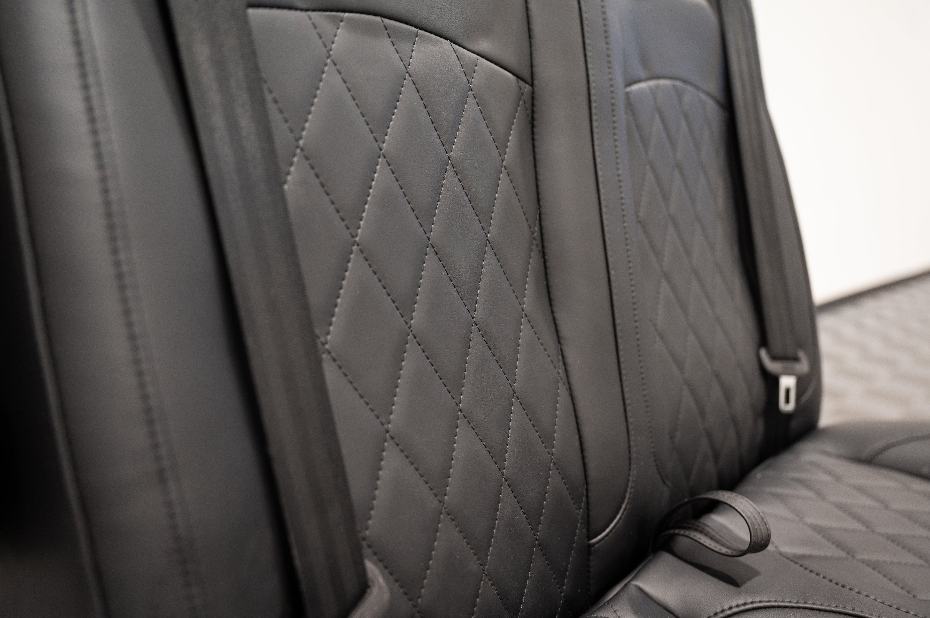 Alpine Van Works dual fold double bench-to-bed seat showing a versatile seating and sleeping solution with cushioned surface and sturdy frame.
