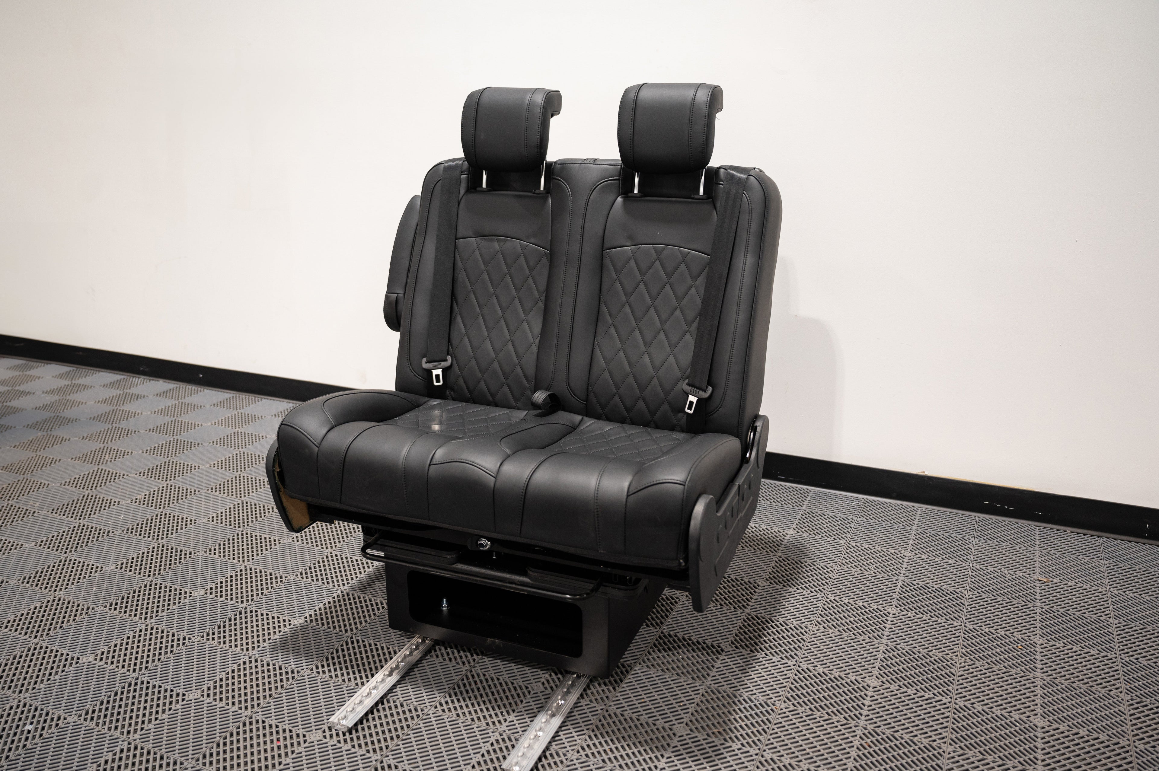 Alpine Van Works dual fold double bench-to-bed seat showing a versatile seating and sleeping solution with padded cushions.