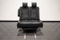Alpine Van Works dual fold double bench-to-bed seat with cushioned seating and folding mechanism for versatile vehicle seating or sleeping area.