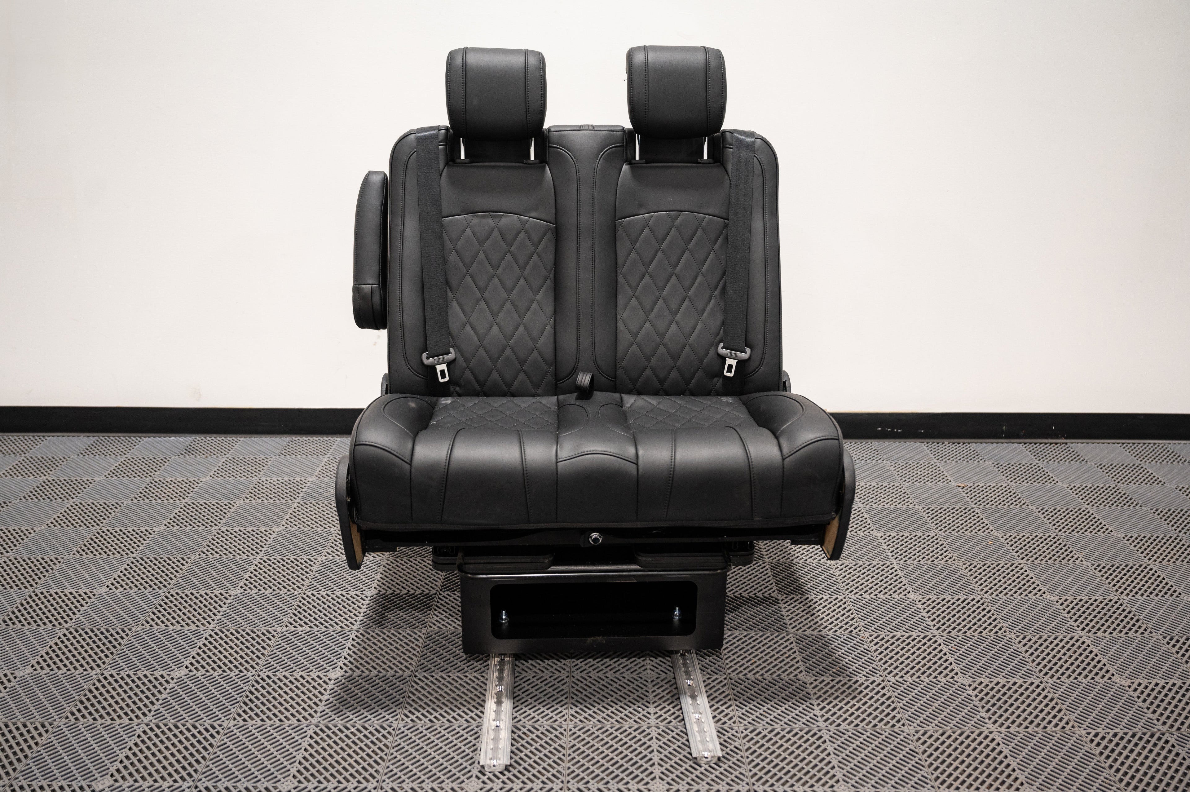 Alpine Van Works dual fold double bench-to-bed seat with cushioned seating and folding mechanism for versatile vehicle seating or sleeping area.