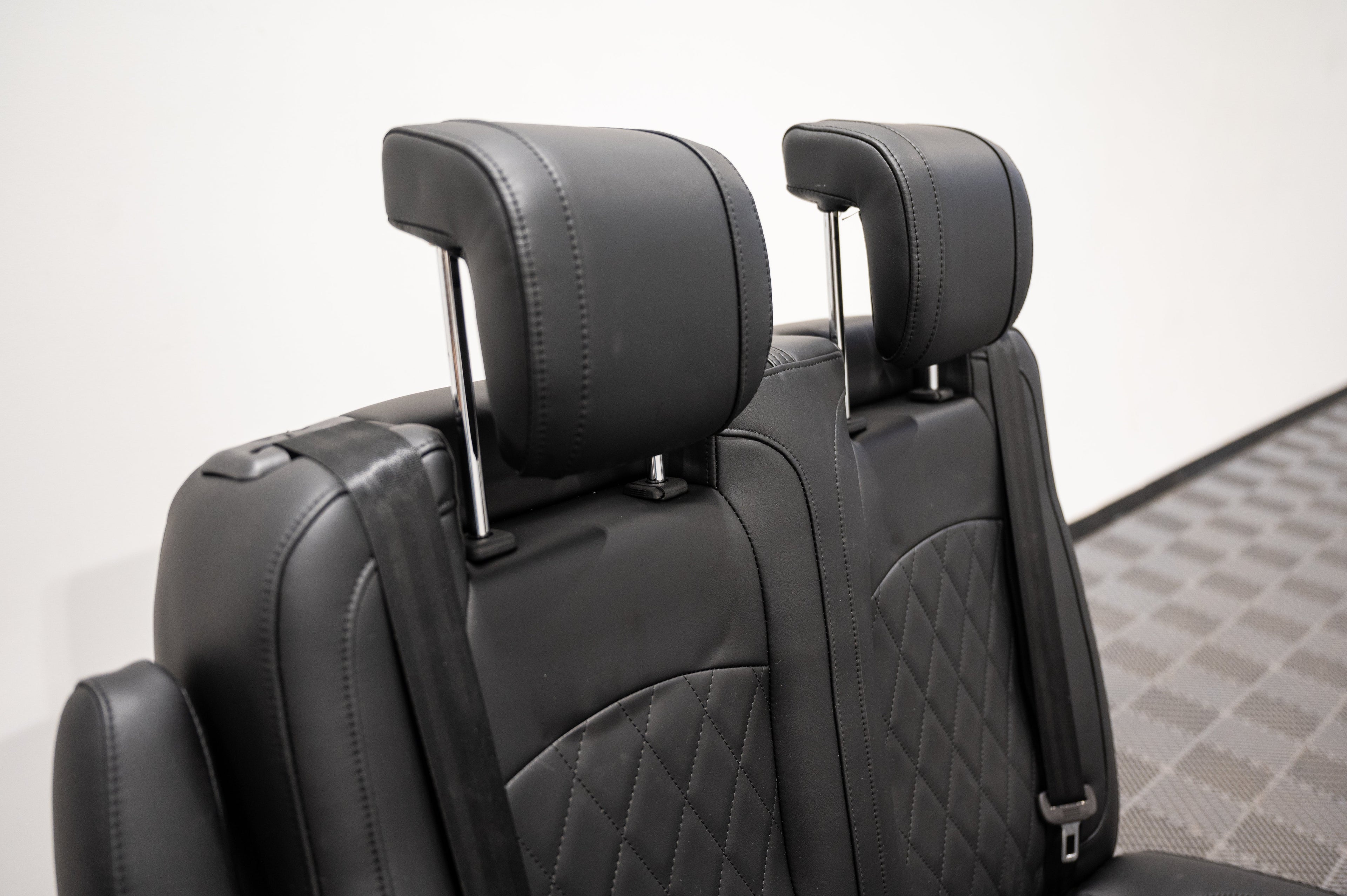Dual fold double bench-to-bed seat by Alpine Van Works, LLC, showing a versatile seating and sleeping solution with cushioned upholstery.
