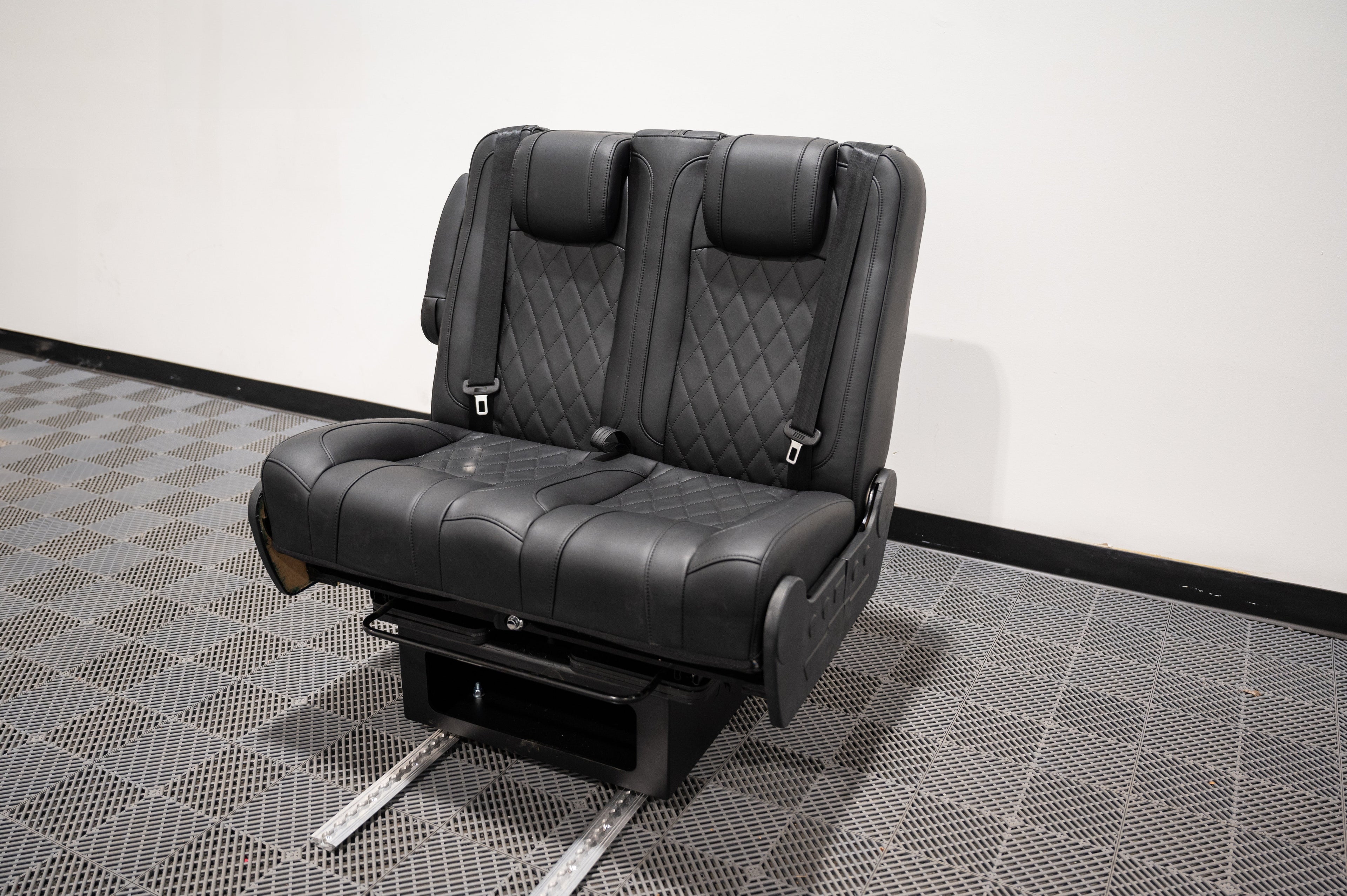 Alpine Van Works double fold bench-to-bed seat showing cushioned seating and compact folded position for versatile RV seating and sleeping.
