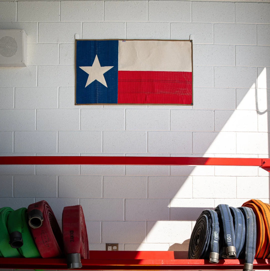 American flag made from fire hose featuring Texas state outline, created by Recycled Firefighter, on a white background.