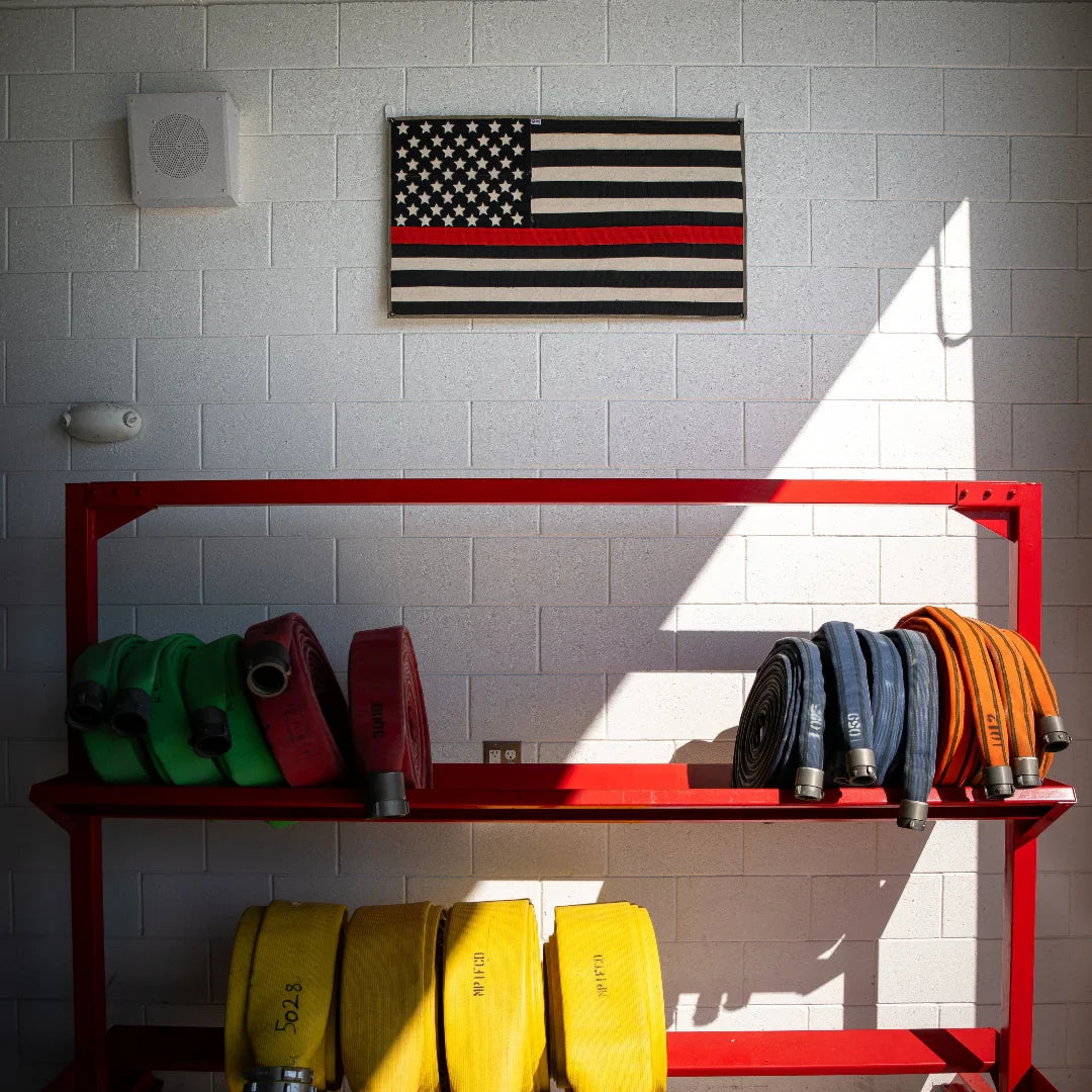 Recycled Firefighter American flag made from fire hose with thin red line on white background, representing firefighter support and pride.