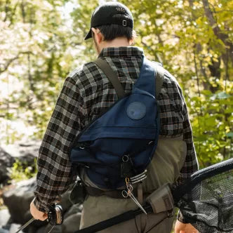 Backcountry Sportsman sling pack with adjustable straps and multiple compartments, shown in a sleek black design.